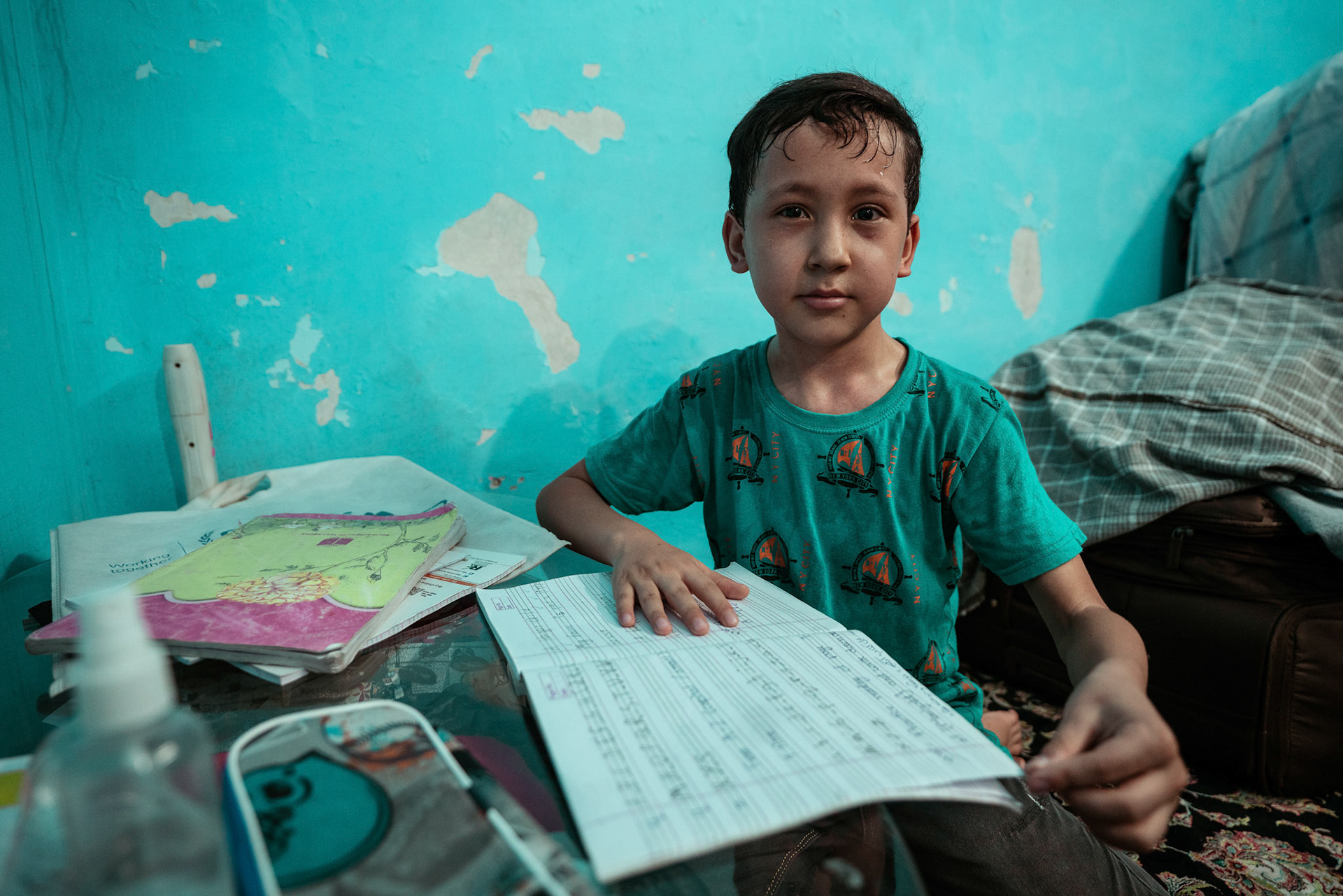 A young Afghan refugee does his homework in Tilak Nagar, Delhi. He suffers from Diabetes.