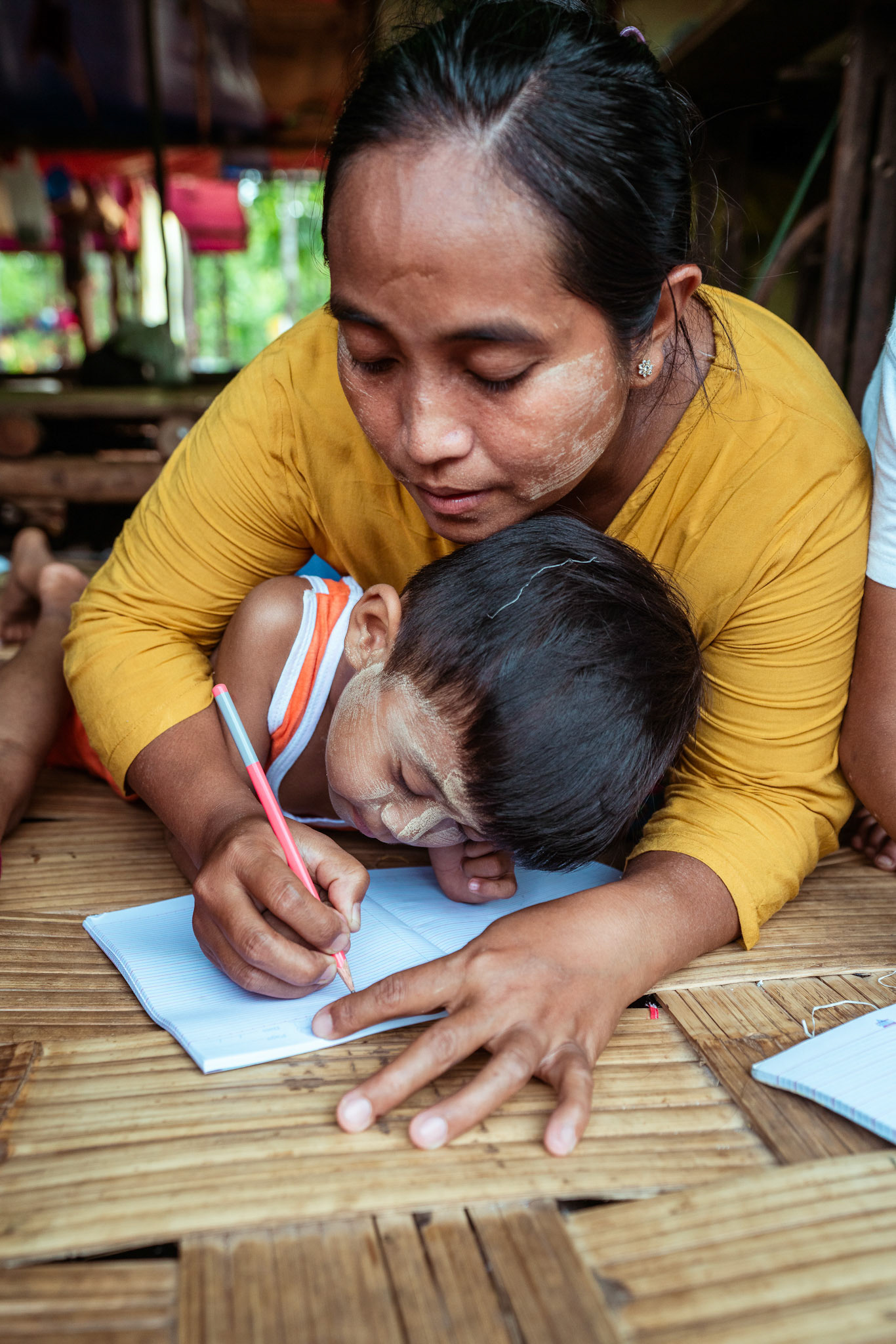 Mothers tutoring their children after attending skill development and adult education modules organised by members of CRS in Moreh, Manipur.