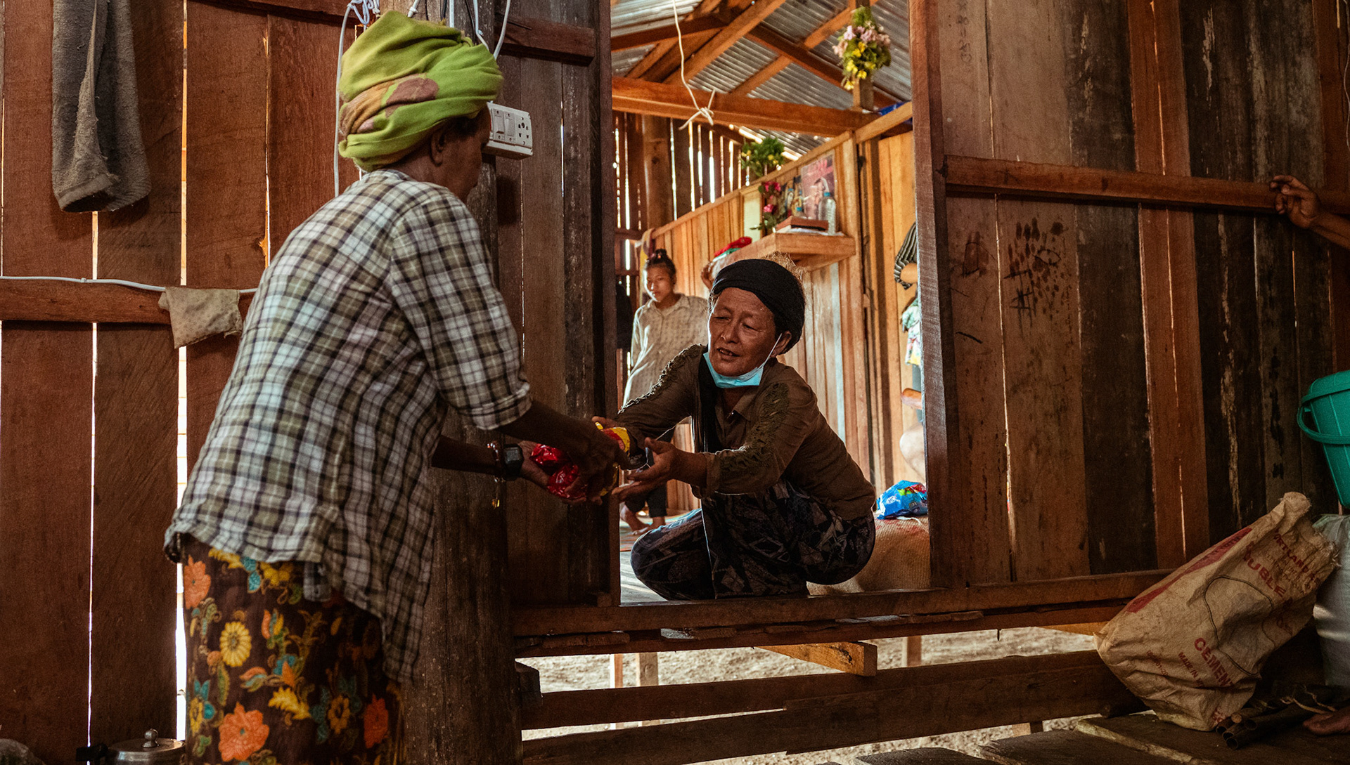 A refugee woman arranging basic needs supplies at her home post collecting them during the Voucher Based Distribution in Moreh, Manipur.