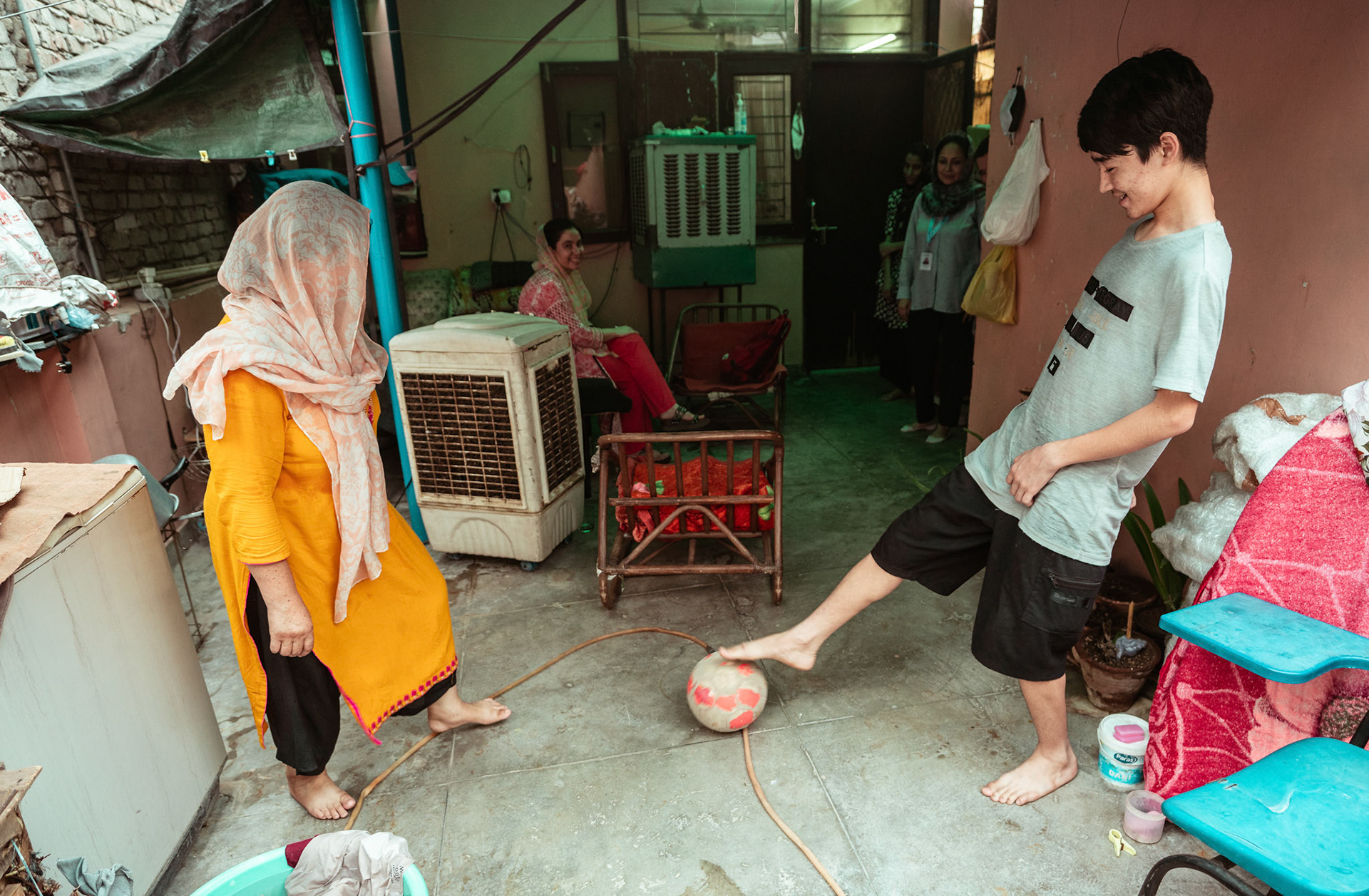 An Afghan refugee mother joins her son's play at their house in Tilak Nagar, Delhi.