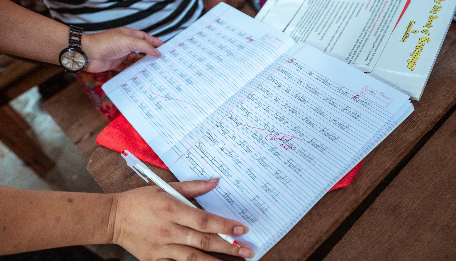 A teachers checks the study material in as part of the adult education module organised by representatives of CRS Moreh, Manipur, during the COVID-19 Response and Recovery Program.