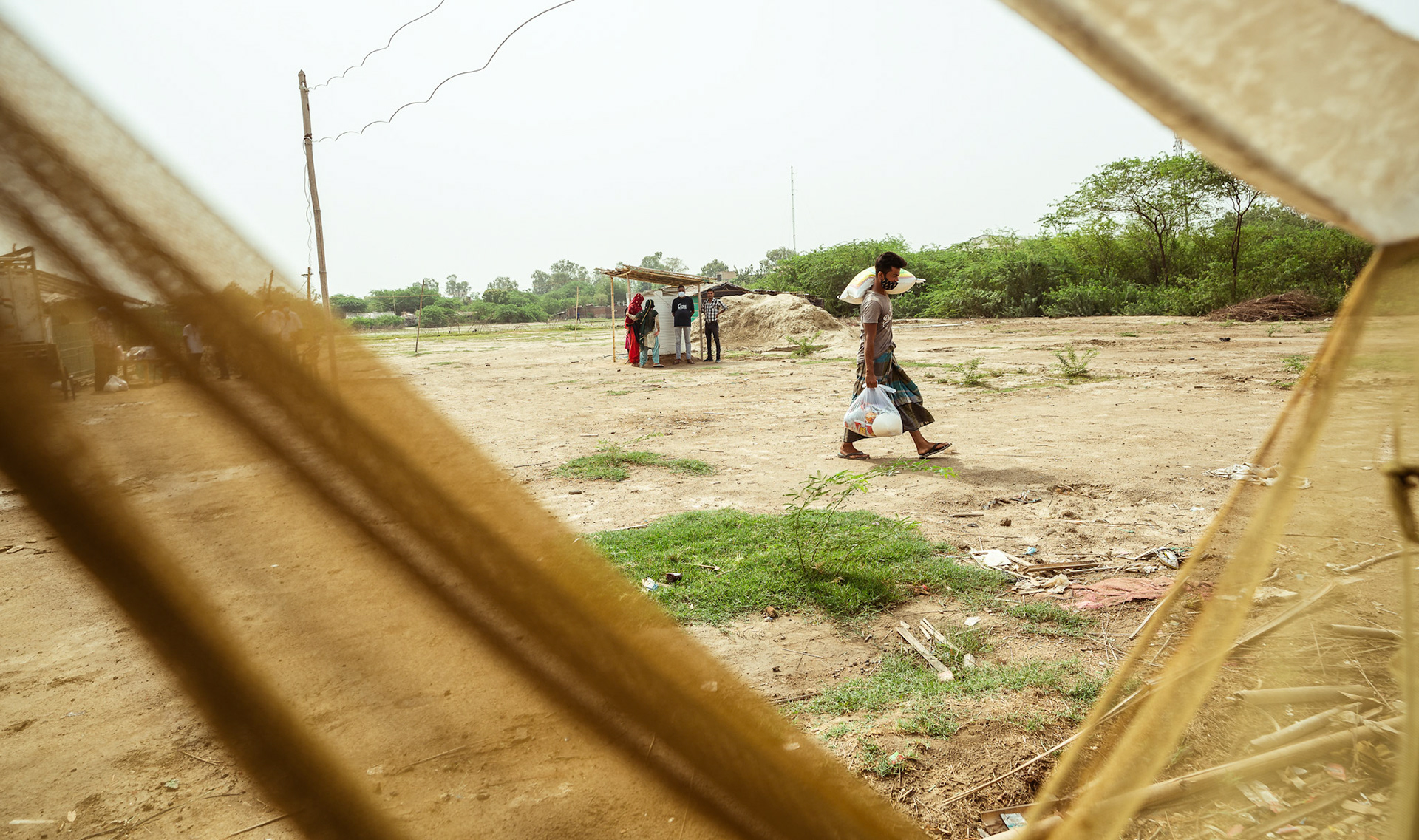 A Rohingya refugee carrying home the basic need supplies and COVID recovery kits distributed by Catholic Relief Services (CRS) as a part of COVID-19 Response and Recovery Program in Mewat, Haryana.