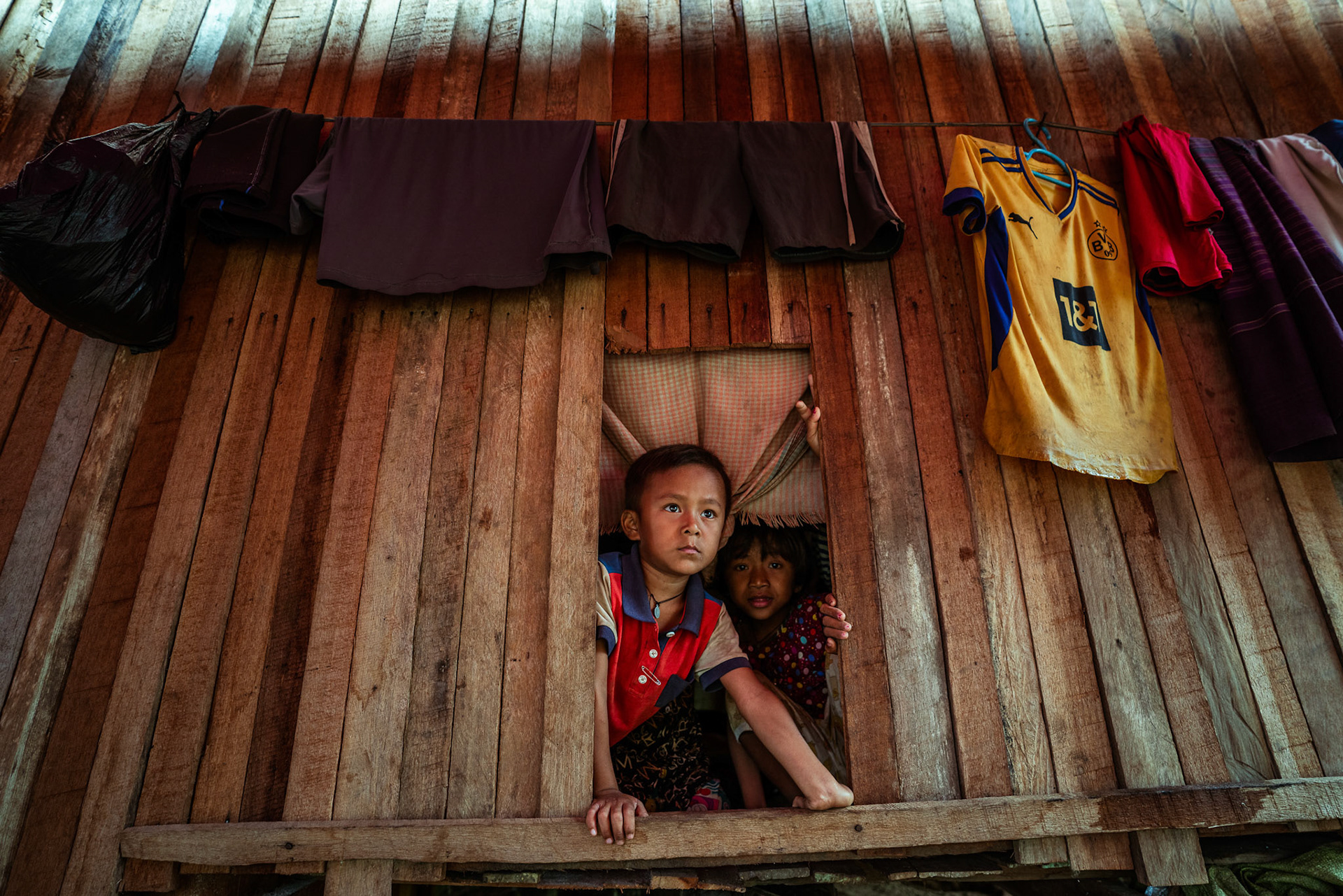 A refugee peeping from his window in Moreh, Manipur, captured  during the COVID recovery program organised by Catholic Relief Services (CRS).