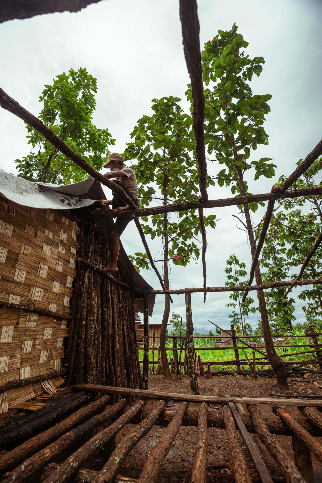 Refugees in Moreh, Manipur, covering their roof with tarpaulin sheets received from the Voucher Based Distribution of basic need supplies and COVID recovery kits among People of Concern (POC) in Moreh, Manipur organised by Catholic Relief Services (CRS).