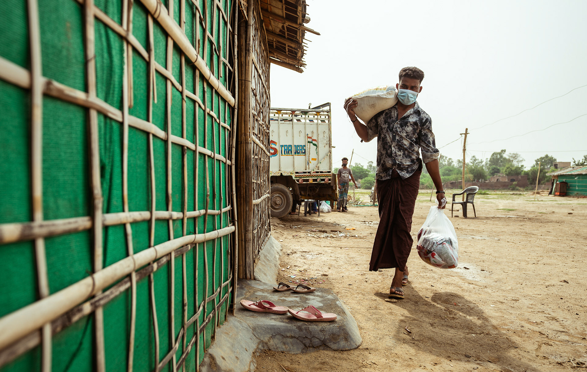 A Rohingya refugee carrying home the basic need supplies and COVID recovery kits distributed by Catholic Relief Services (CRS) as a part of COVID-19 Response and Recovery Program in Mewat, Haryana.