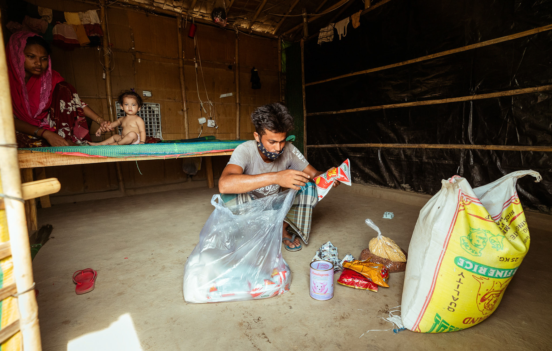 A Rohingya refugee unpacking the basic need supplies and COVID recovery kits distributed by Catholic Relief Services (CRS) as a part of COVID-19 Response and Recovery Program in Mewat, Haryana.