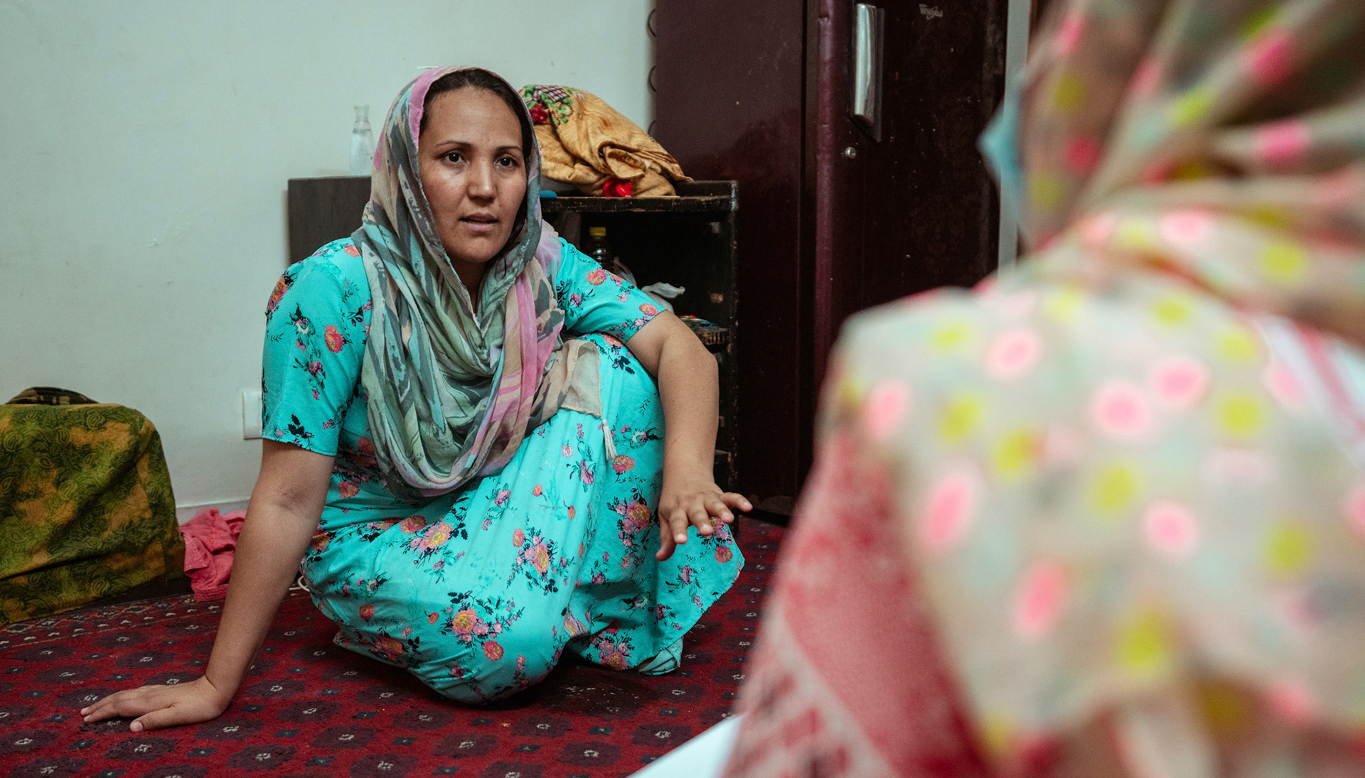 Representatives of Catholic Relief Services (CRS) speaking to a refugee in Tilak Nagar, Delhi about COVID Appropriate Behaviour, Gender based violence and child protection.