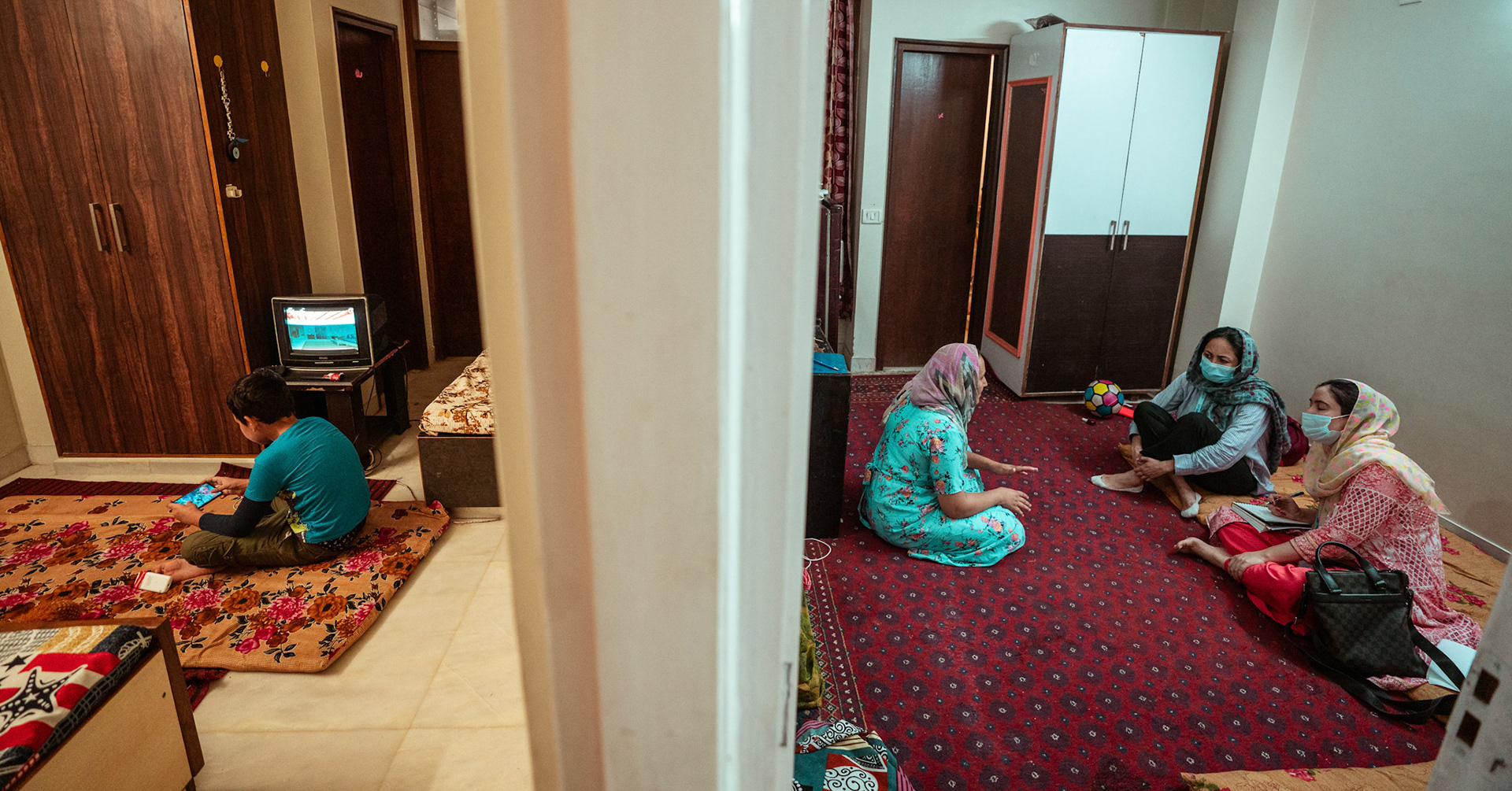 Representatives of Catholic Relief Services (CRS) speaking to a refugee in Tilak Nagar, Delhi about COVID Appropriate Behaviour, Gender based violence and child protection.