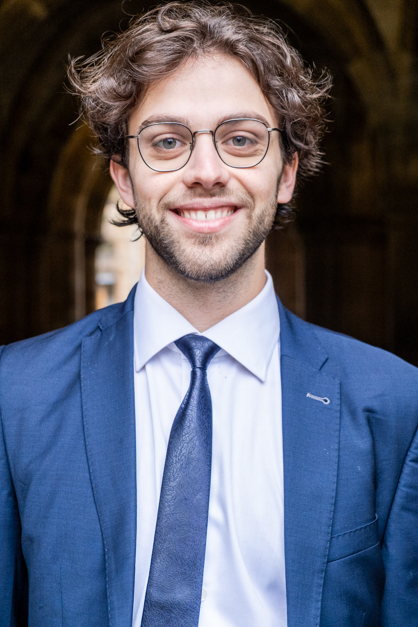Portrait of a man with the University of Glasgow cloisters in the background