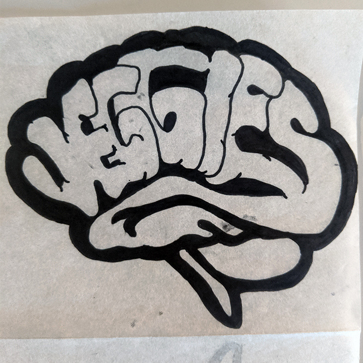 A picture drawn on tracing paper in sharpie. The brain uses the folds of the brain to create the word veggies.