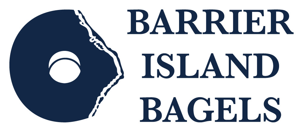 The Barrier Island Bagels logo in the color navy blue. It features the logo mark on the left and text on the right in a centered serif typeface. The logo mark is designed to be a bagel with a bite out of it. The bite out of the bagel creates the shape of the Barrier Islands in North Carolina.