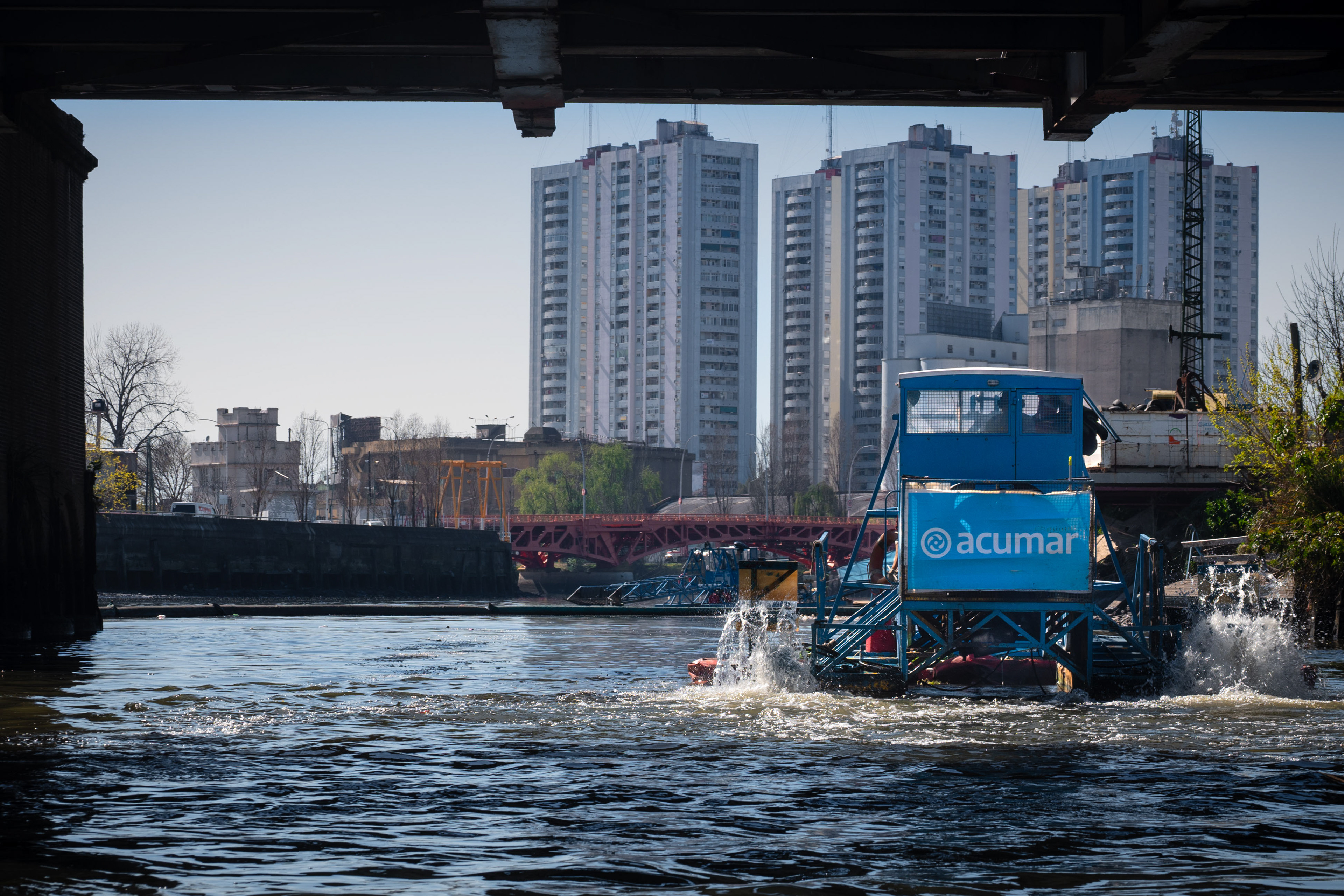 An ACUMAR river cleaning boat circulates the Riachuelo from one end to the other, collecting waste from the surface, as part of the squads that control the waste dumped by neighboring industries. The most polluted river in Buenos Aires is facing new difficulties due to the closure of the agency responsible for its sanitation (ACUMAR).