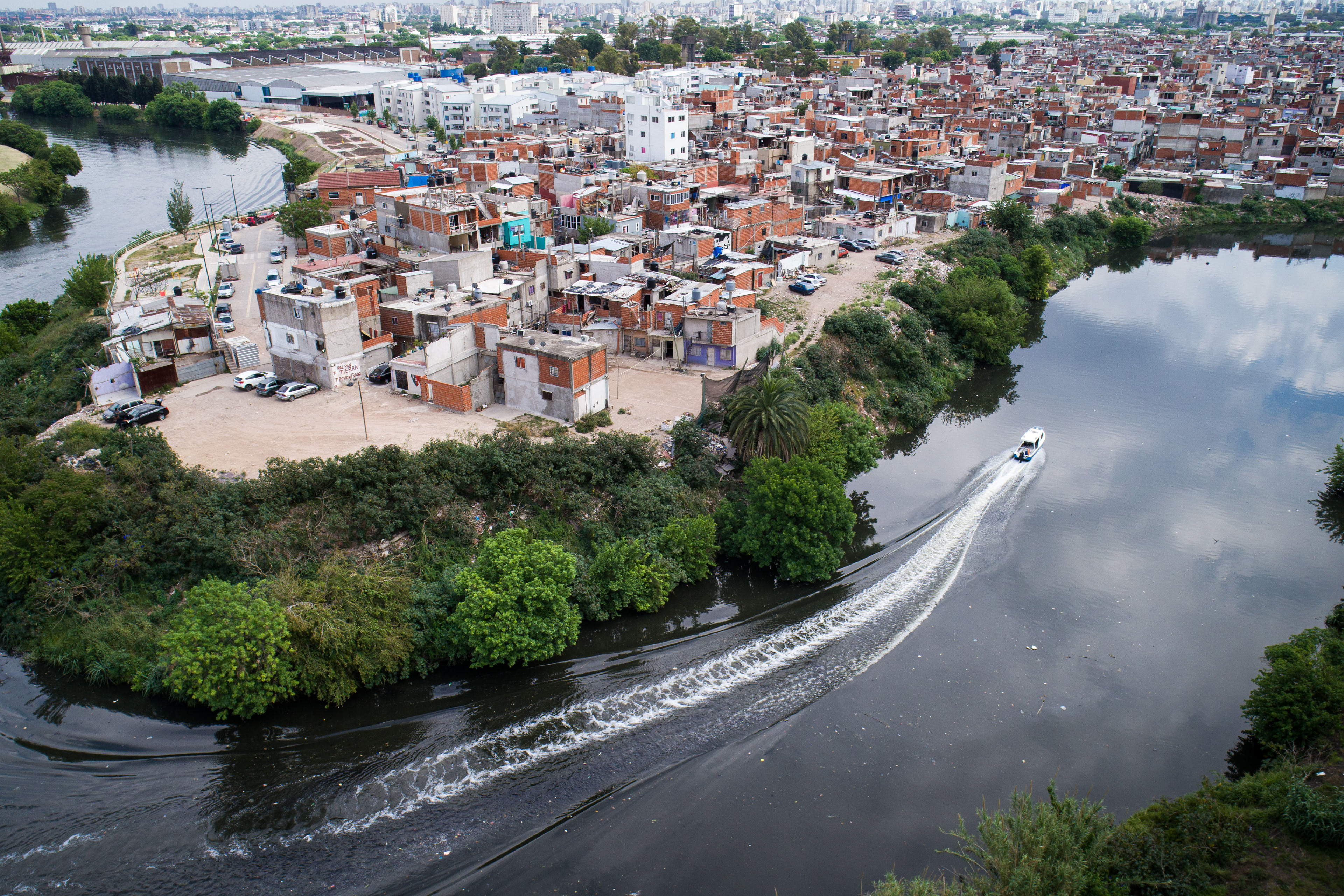 Arial view of a boat passing homes in the poor neighborhood of Zavaleta on the banks of the Riachuelo River. Thousands of businesses, such as tanneries, chemical plants and factories, are situated in the basin, while an estimated 4.5 million people call the area home.