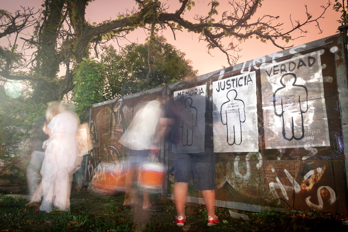 Un grupo de vecinos pegan los afiches con las siluetas de los desaparecidos en el marco del día de la memoria, en Béccar, Buenos Aires, Argentina, el 23 de marzo de 2022. FOTO/Igor Wagner