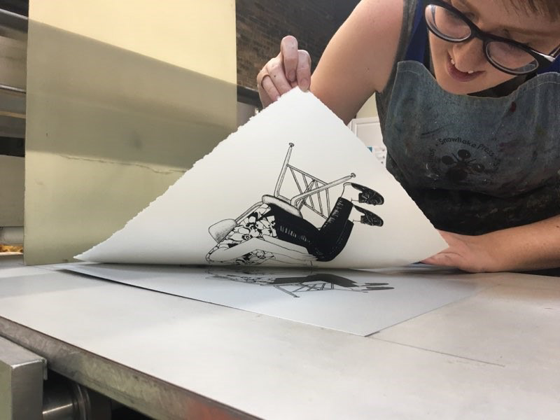Trishelle Jeffery, instructor, pulling a photo-plate lithography proof.