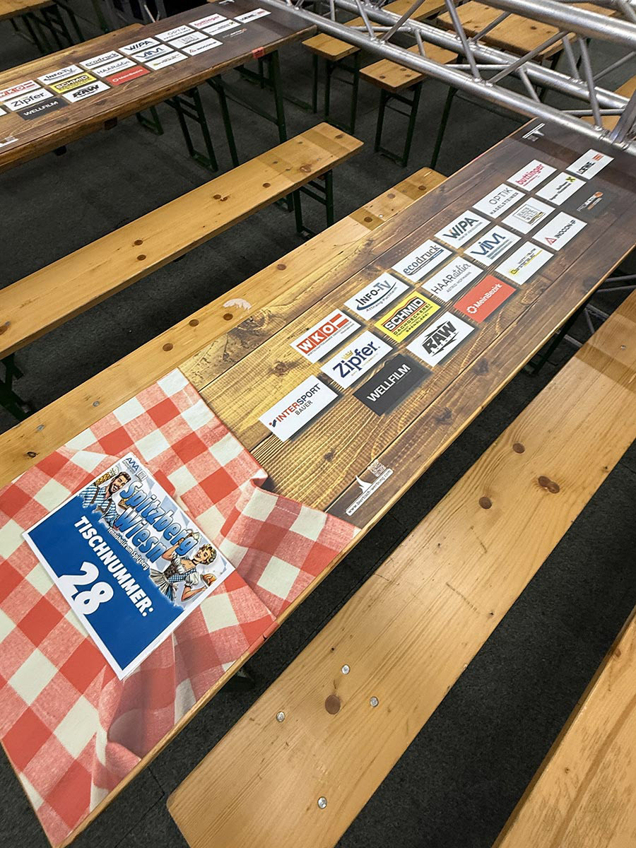 Karierte Tischdecke mit Holzoptik Auflage und Werbung am Tisch