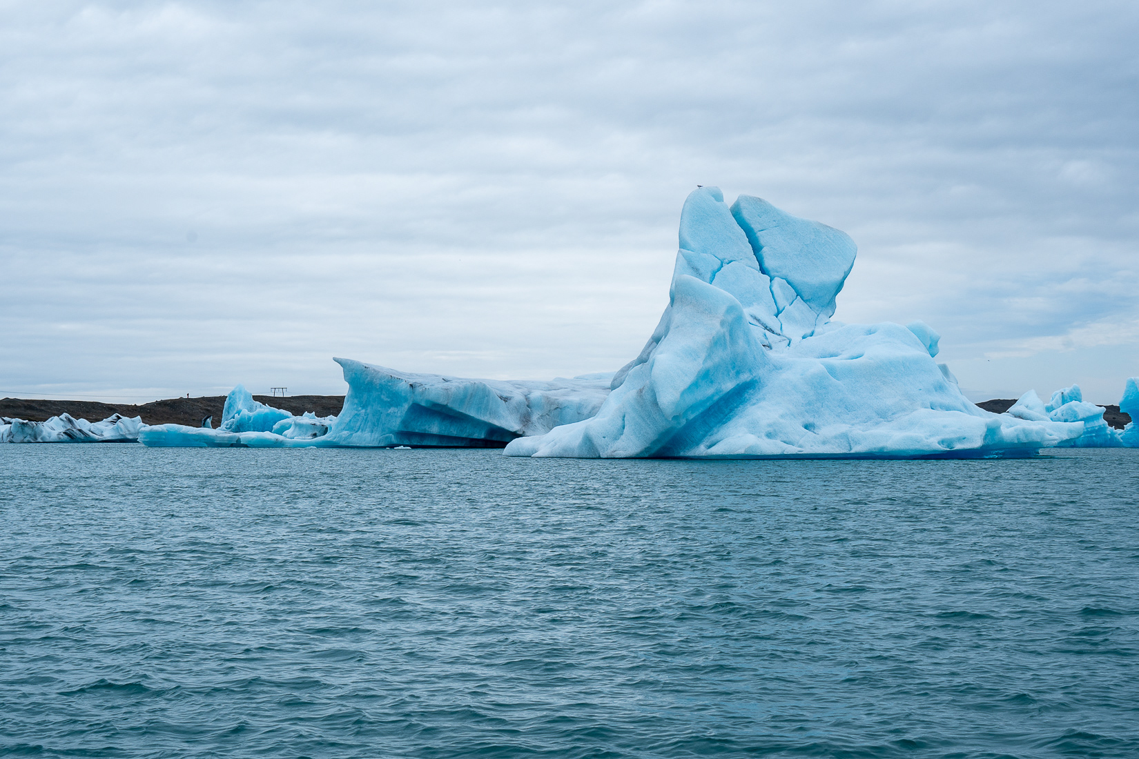 The blue color is caused by the compression of the snow crystals and the air bubbles being squeezed out.