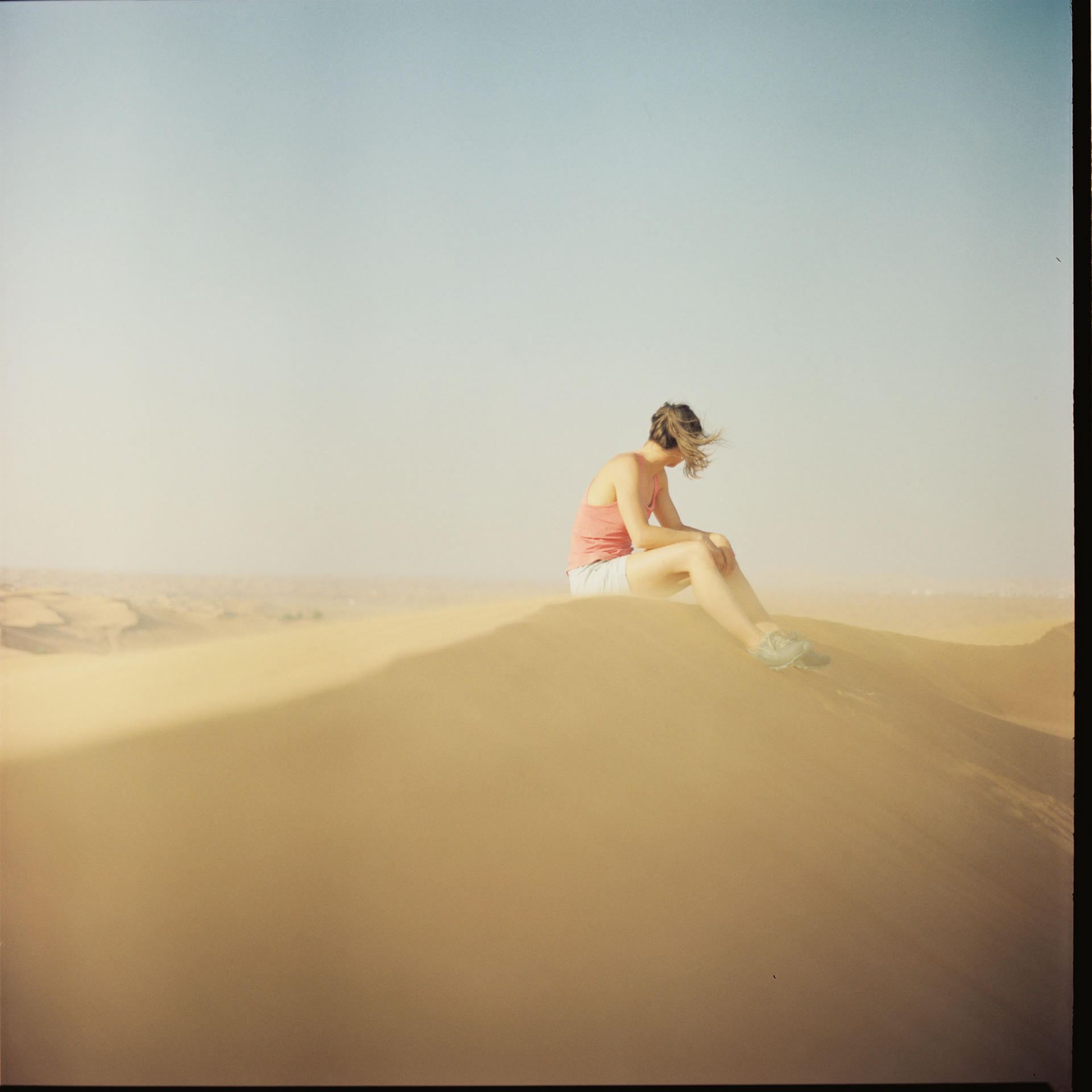Esther, sheltering from the wind-whipped sand
