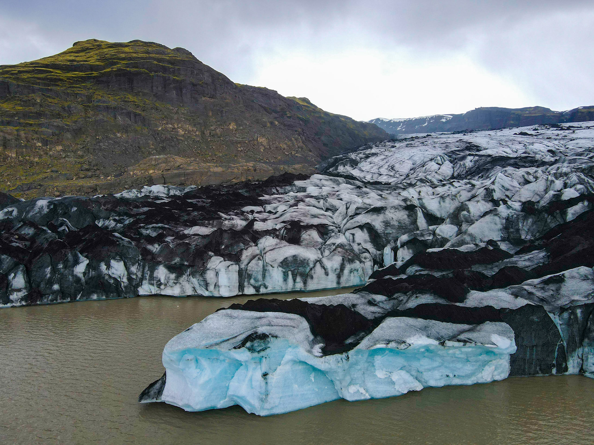 Bordure ouest de la falaise du Sólheimajökull, surplombant le lac glaciaire. La couleur noire provient des cendres volcaniques piégées dans la glace