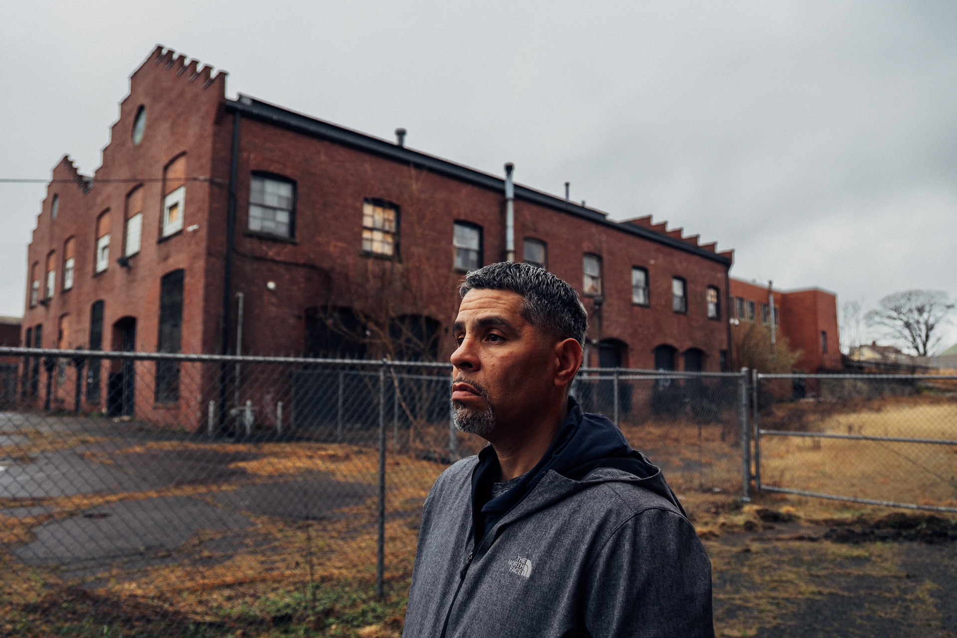 Diego Lopez, a former member of the Latin Kings gang in Connecticut, now dedicates his life as a social worker in Hartford, helping others overcome similar struggles. He bears the physical marks of his past – tattoos, scars, and gunshot wounds, including one that resulted in the amputation of a finger. Photographed on the streets of Hartford, Connecticut on April 11, 2024, Lopez's story is a powerful testament to resilience and transformation.