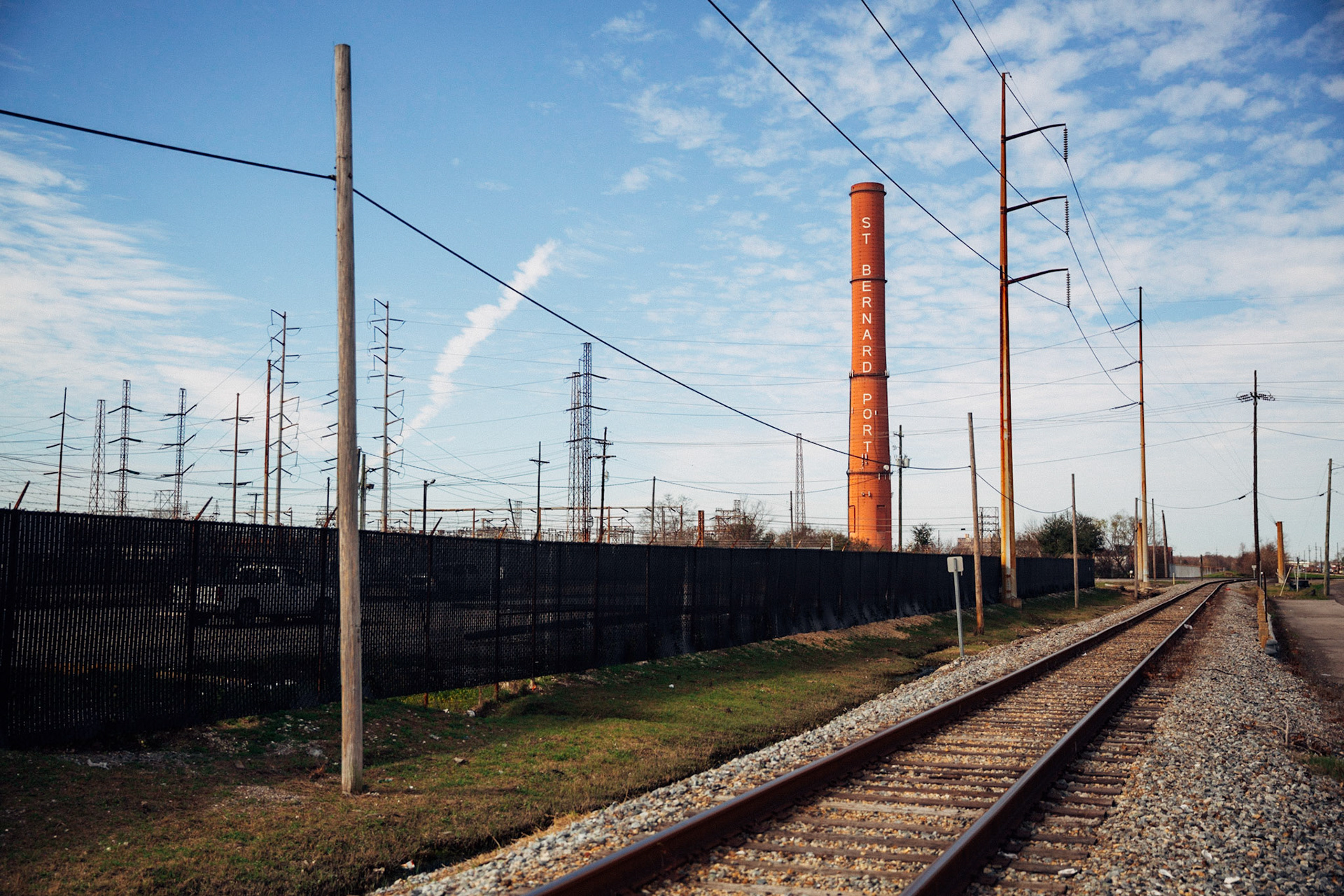 Smokestack or Chimney and train tracks in Saint Bernard Parish Port, Louisiana, USA, 2017. CISLANDERUS is the cultural project about the Descendants of Canary Islanders in the US. www.cislanderus.com | Researcher: Thenesoya V. Martín |  Photographer: Aníbal Martel.