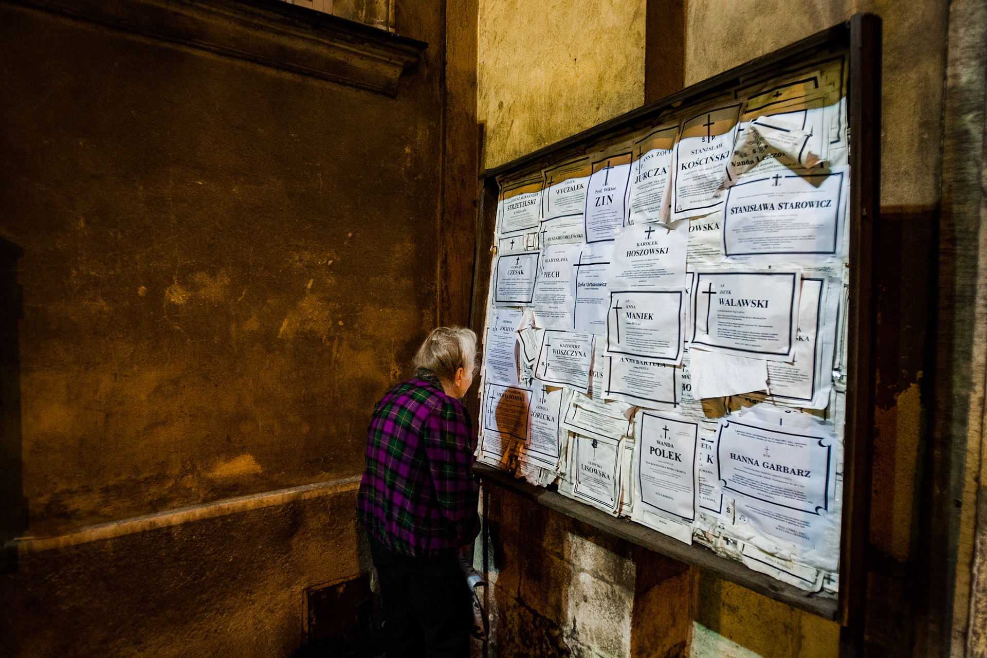 Elderly woman searching among the obituaries, Kazimierz, Kraków, Poland, 2007.