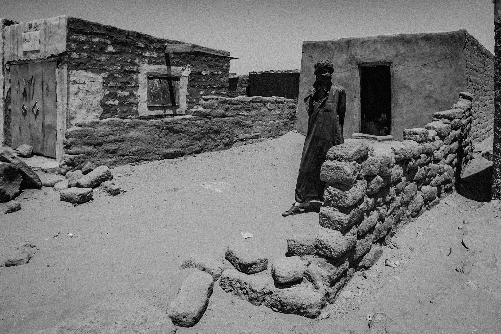 Dakhla refugee camp, Tindouf, Wilaya de Tindouf, Algerian Sahara, 2009: Man waiting in front of the door of his house built with adobe bricks.