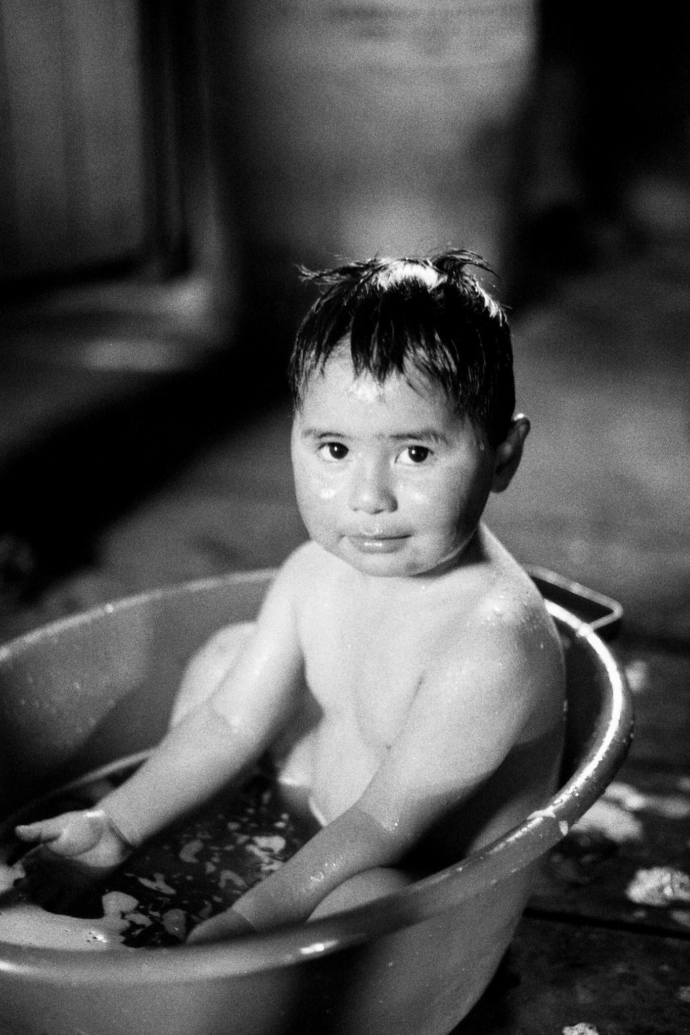 LLUFQUENTUE AREA, IX ARAUCANIA REGION, CHILE - 2014: One of the children in the family taking a bath in a basin.