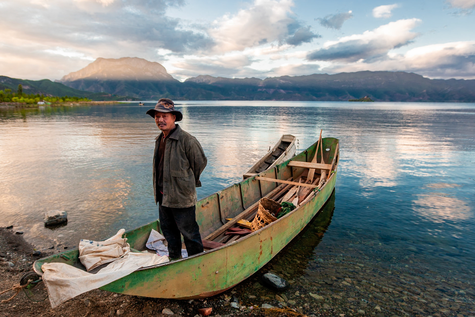 Fisherman at sunset in a boat, Lugu Lake, Yunnan, China, Asia, 2008.