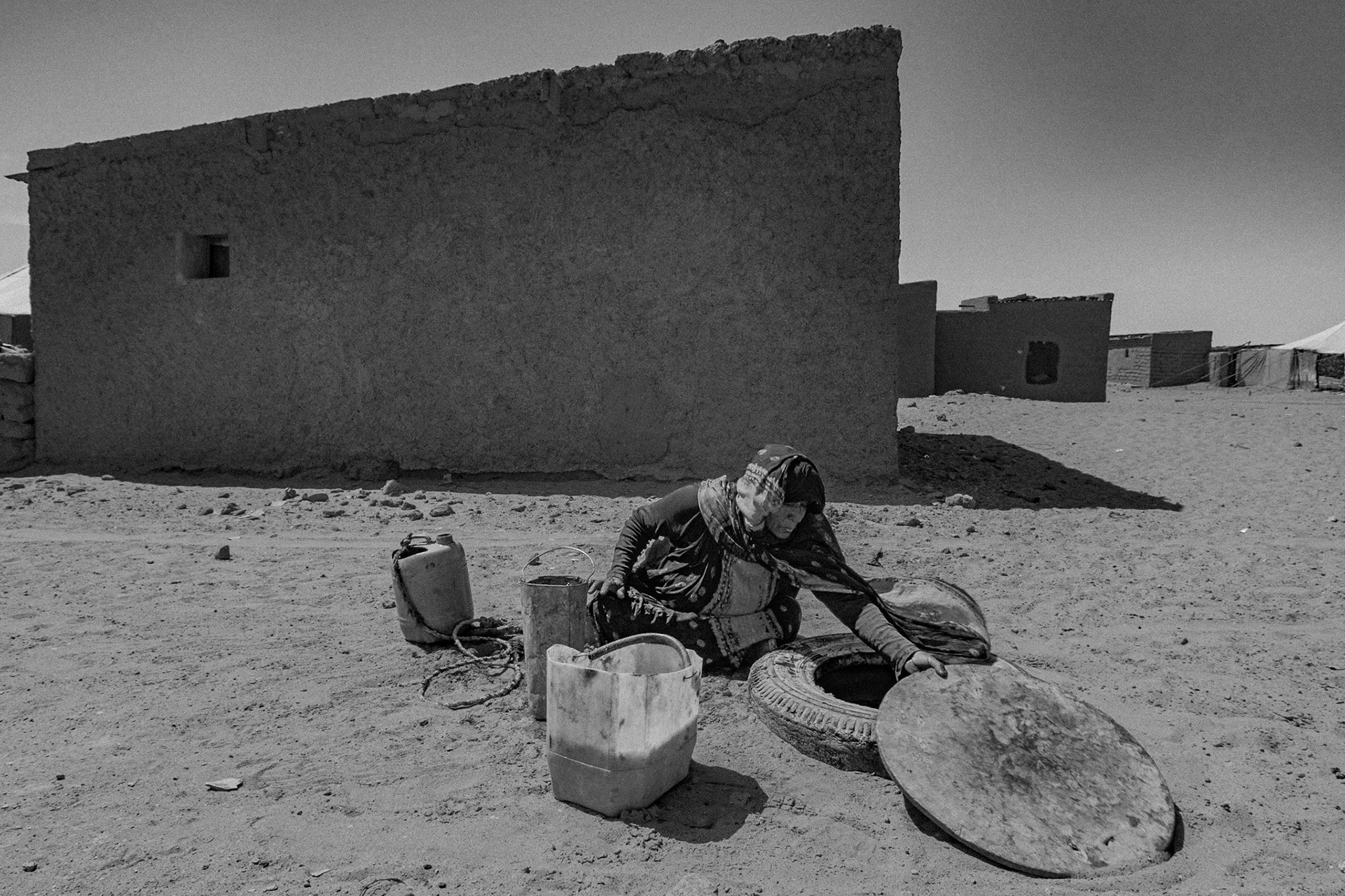 Dakhla refugee camp, Tindouf, Wilaya de Tindouf, Algerian Sahara, 2009: Woman drawing water from the well in front of her house.