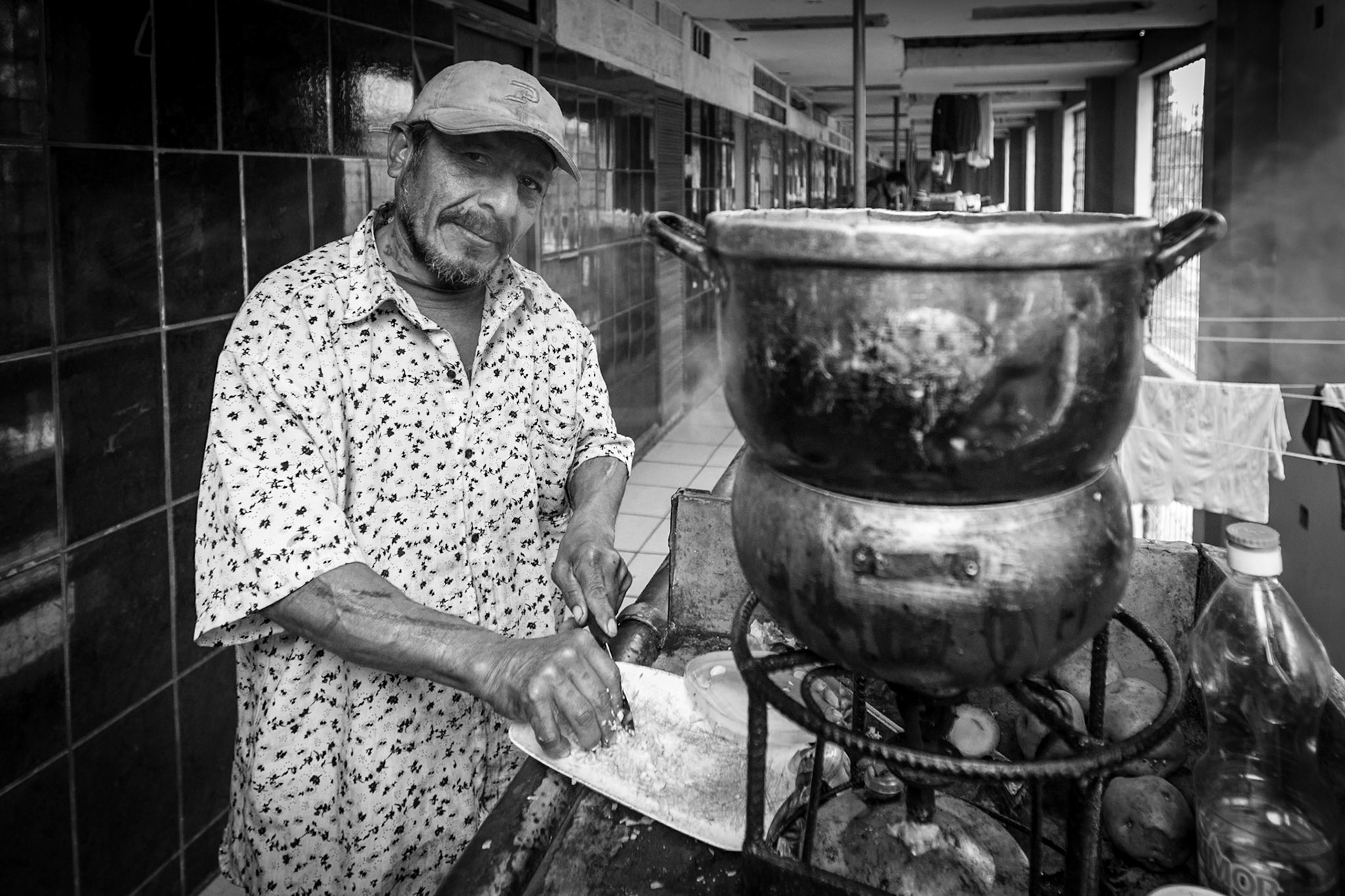 LURIGANCHO PENITENTIARY, SAN JUAN DE LURIGANCHO, LIMA, PERU: One of the prisoners cooking in the middle of the prison corridors.