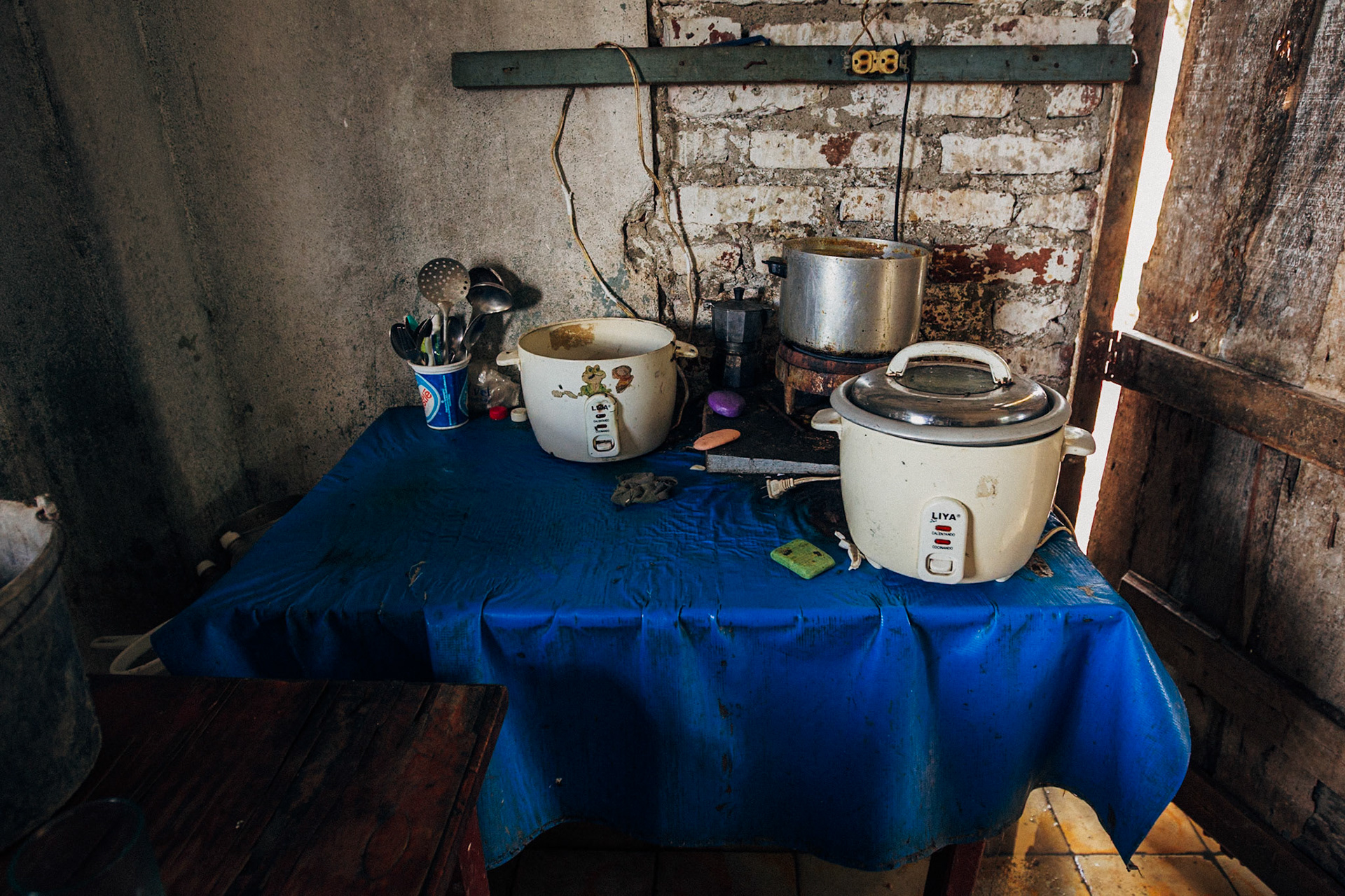 Jatibonico, Cuba — January 1, 2012. On the 54th anniversary of the Cuban Revolution, Yakeline has spent four years waiting for the state housing allocation she was promised. In the meantime, she and her husband raise their five children in the old baseball stadium’s scoreboard building—one room for sleeping, the upper level improvised as a bathroom. With no running water or electricity, they rely on neighbors while hoping for something better.