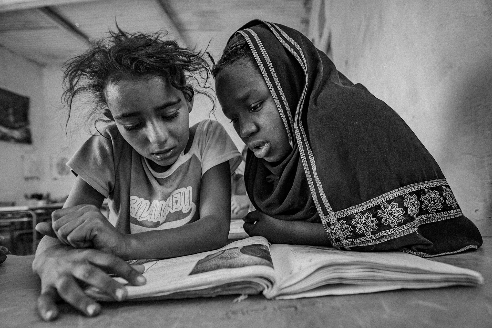 Dakhla refugee camp, Tindouf, Wilaya de Tindouf, Algerian Sahara, 2009: Two girls sharing book at school.