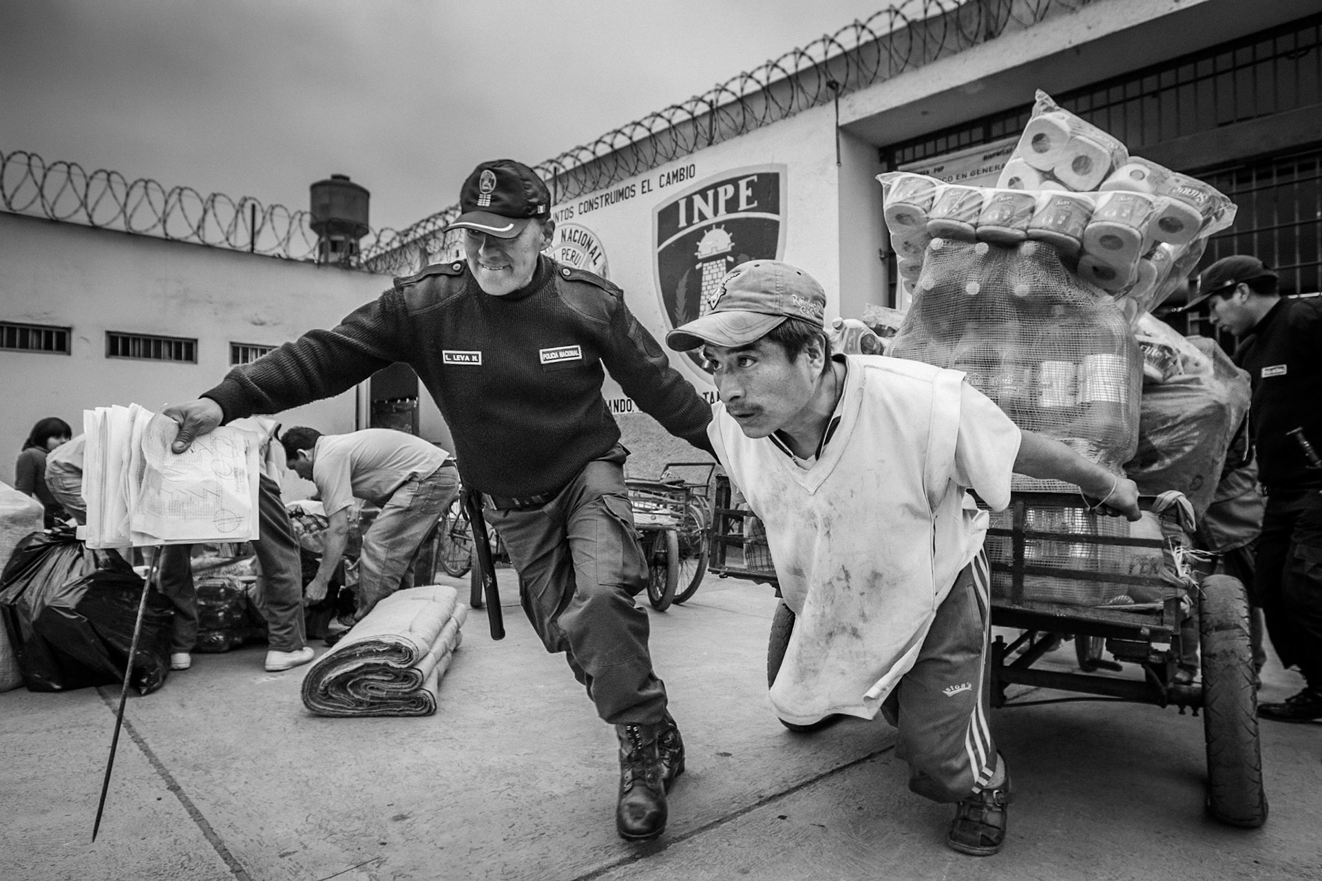 LURIGANCHO PRISON, SAN JUAN DE LURIGANCHO, LIMA, PERU: One of the inmates who works as a transporter tries to move, with the help of one of the police officers, the merchandise cart sent by relatives from abroad. Many of these products are shipped from abroad to supply the food establishments run by the prisoners themselves.
