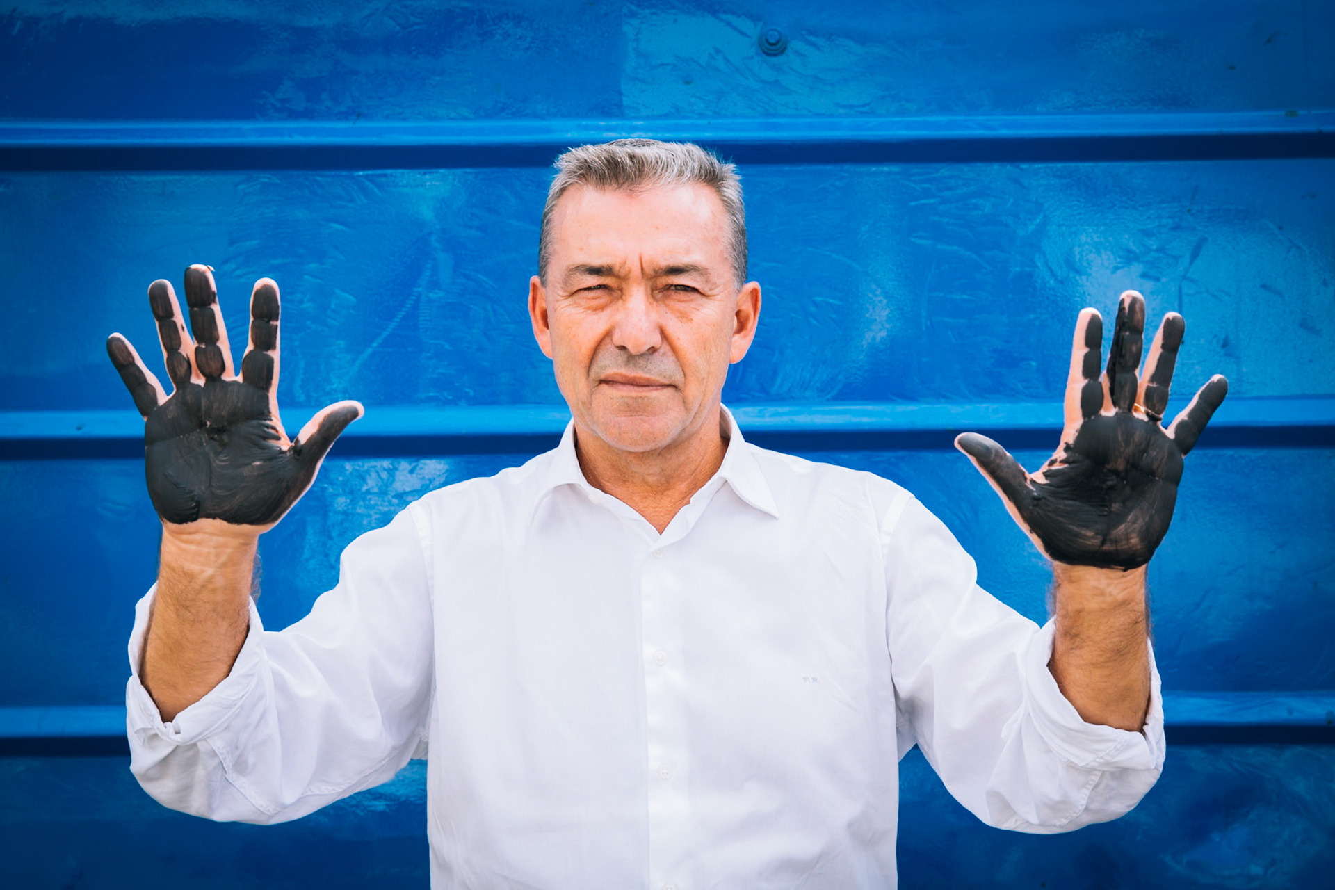 FUERTEVENTURA, CANARY ISLANDS, SPAIN, SEPTEMBER 20, 2014: Paulino Rivero Baute, President of the Government of Canary Islands (2007-2015), is shown against with his hands painted black (Not Oil Drilling in Canary Islands).