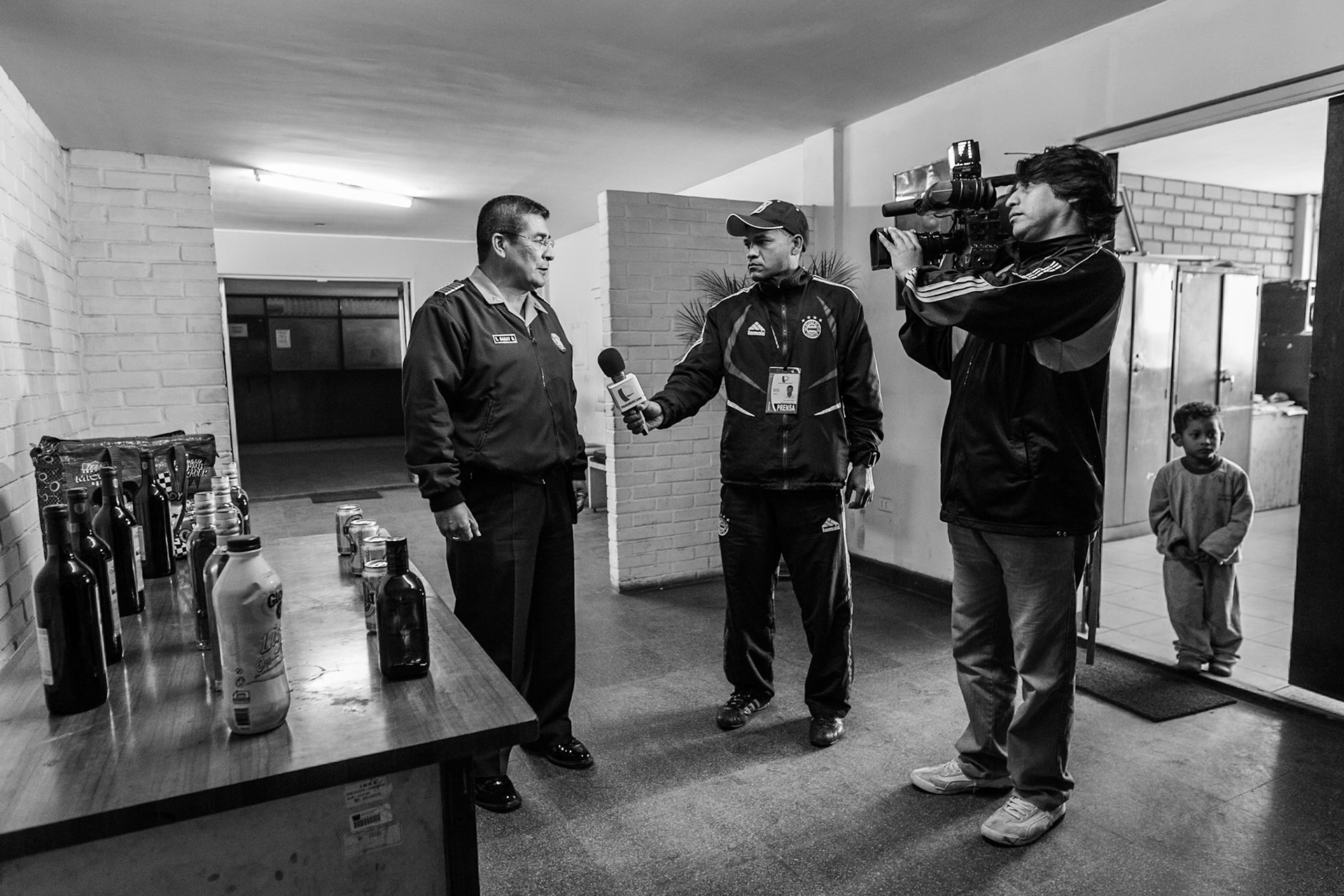 LURIGANCHO PRISON, SAN JUAN DE LURIGANCHO, LIMA, PERU: Television interview with the prison director (T. Garay) after seizing prohibited supplies brought in by one of the women on visiting day. In the background, a minor who accompanied the detained woman.