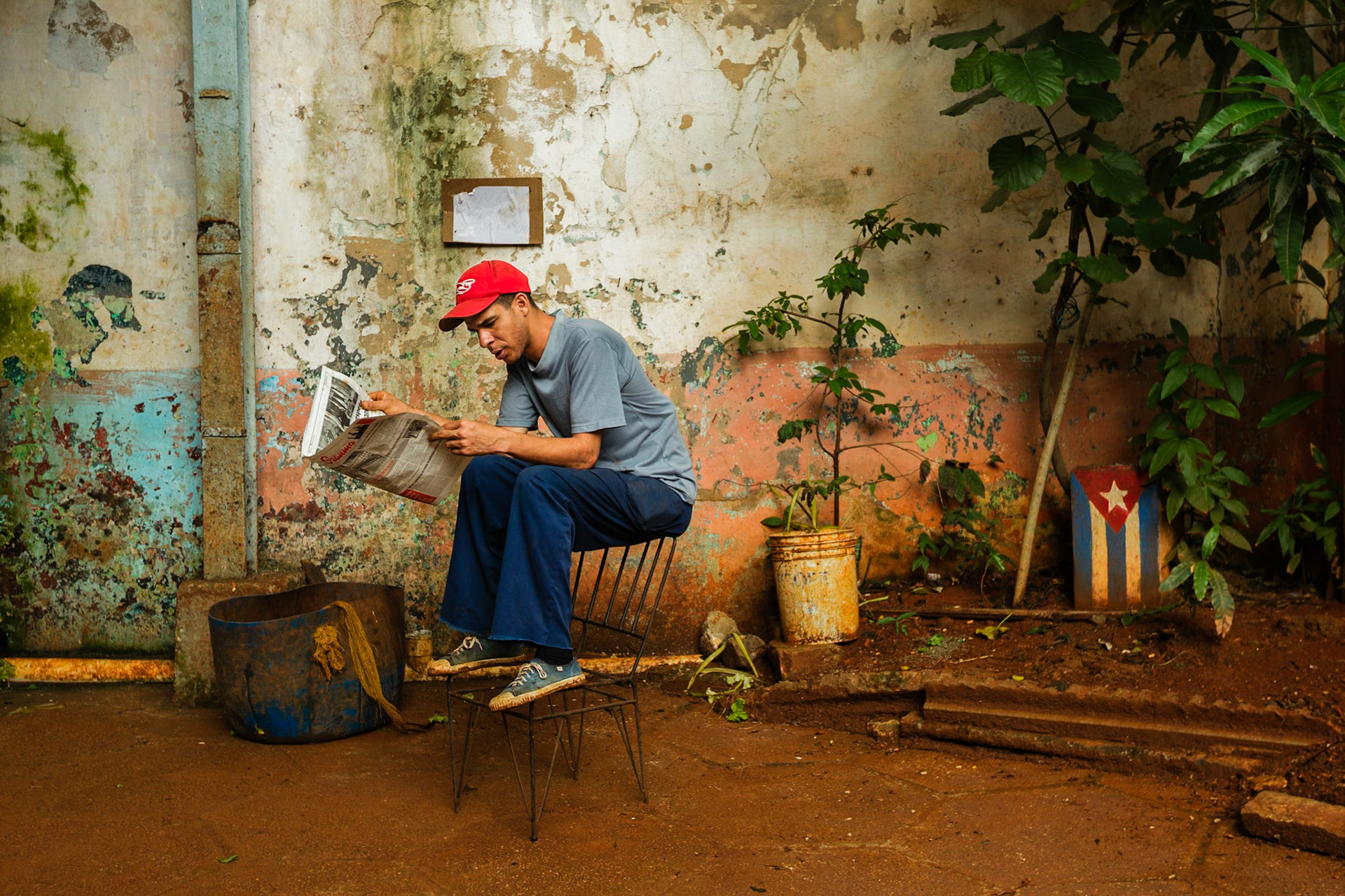 Havana, Cuba - January 12, 2012: A man reads Granma, Cuba’s official newspaper, in a courtyard in Havana.