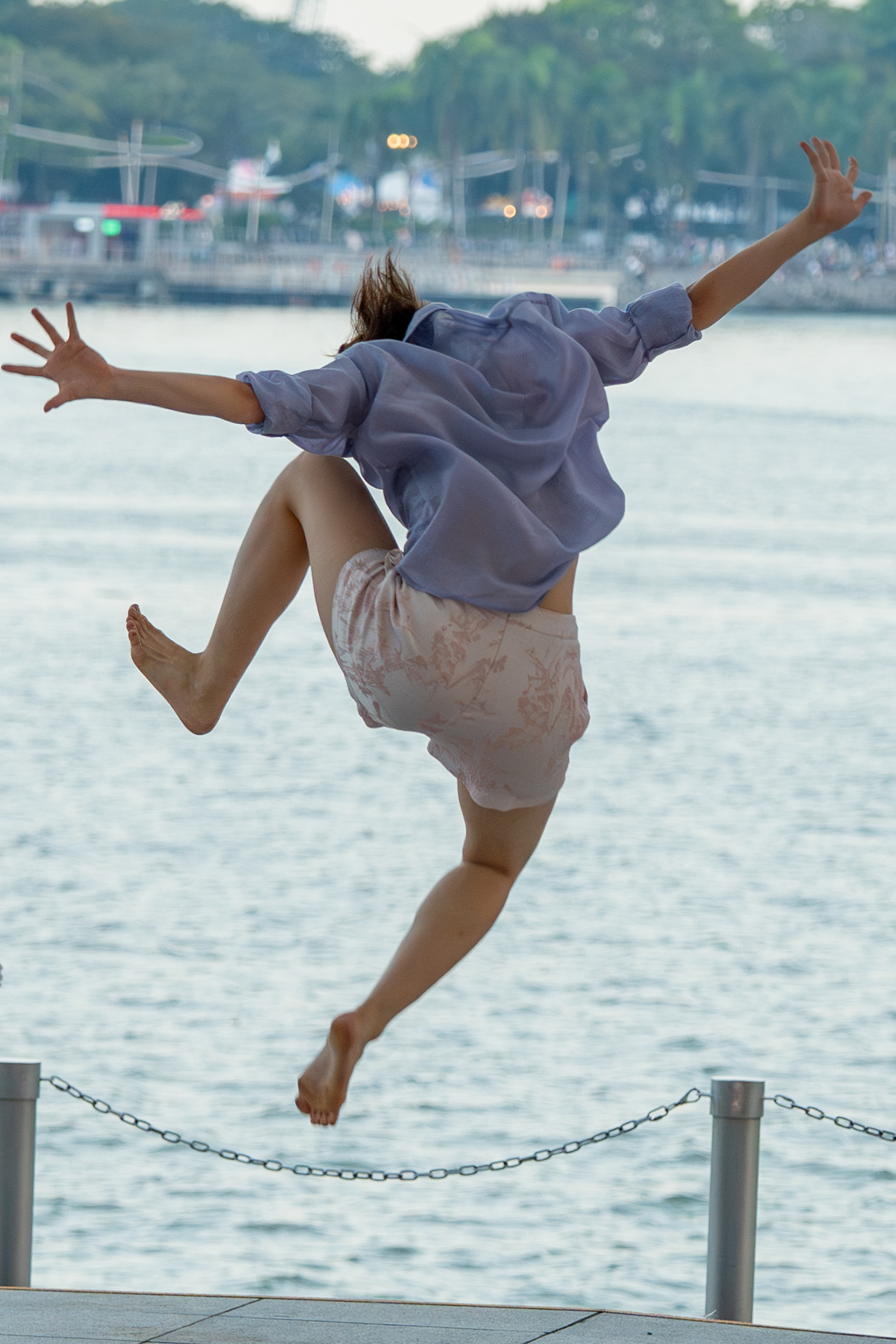 . Alone in the Air. A dancer held at the top of a leap above the bay. Esplanade. Singapore, 2026.