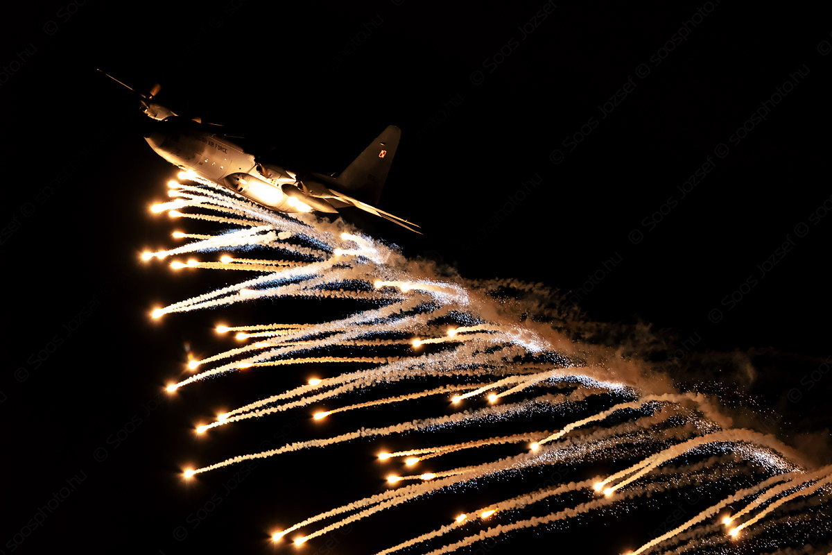 Polish Air Force C-130E Hercules transport aircraft releasing flares during the night program