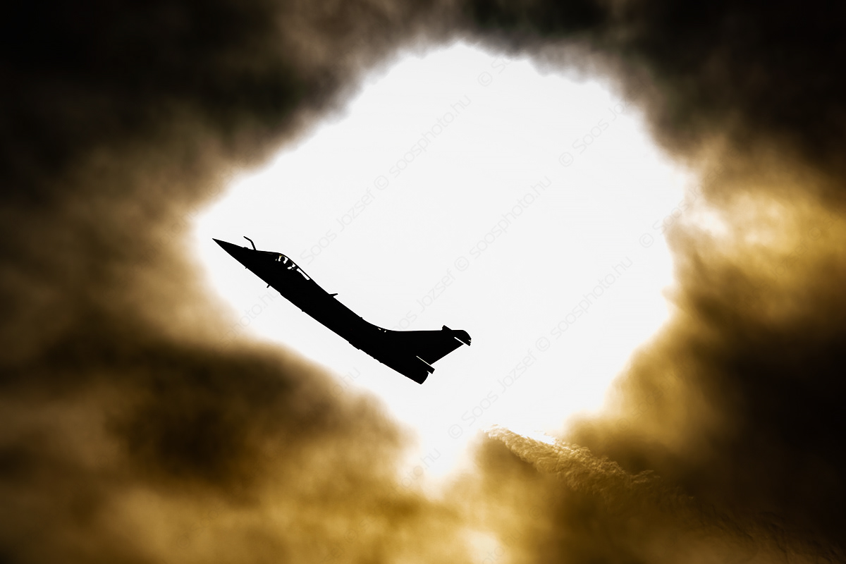 French Air Force Dassault Rafale C in front of the sun filtered by clouds