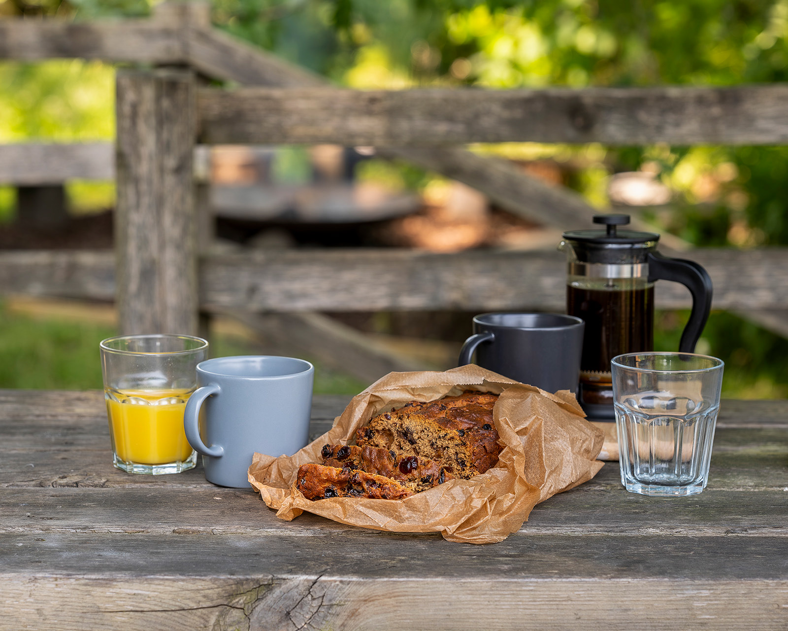 A relaxed breakfast at Roost Merthyr Tydfil, with fresh coffee, orange juice and traditional Welsh bara brith served at the outdoor picnic table.