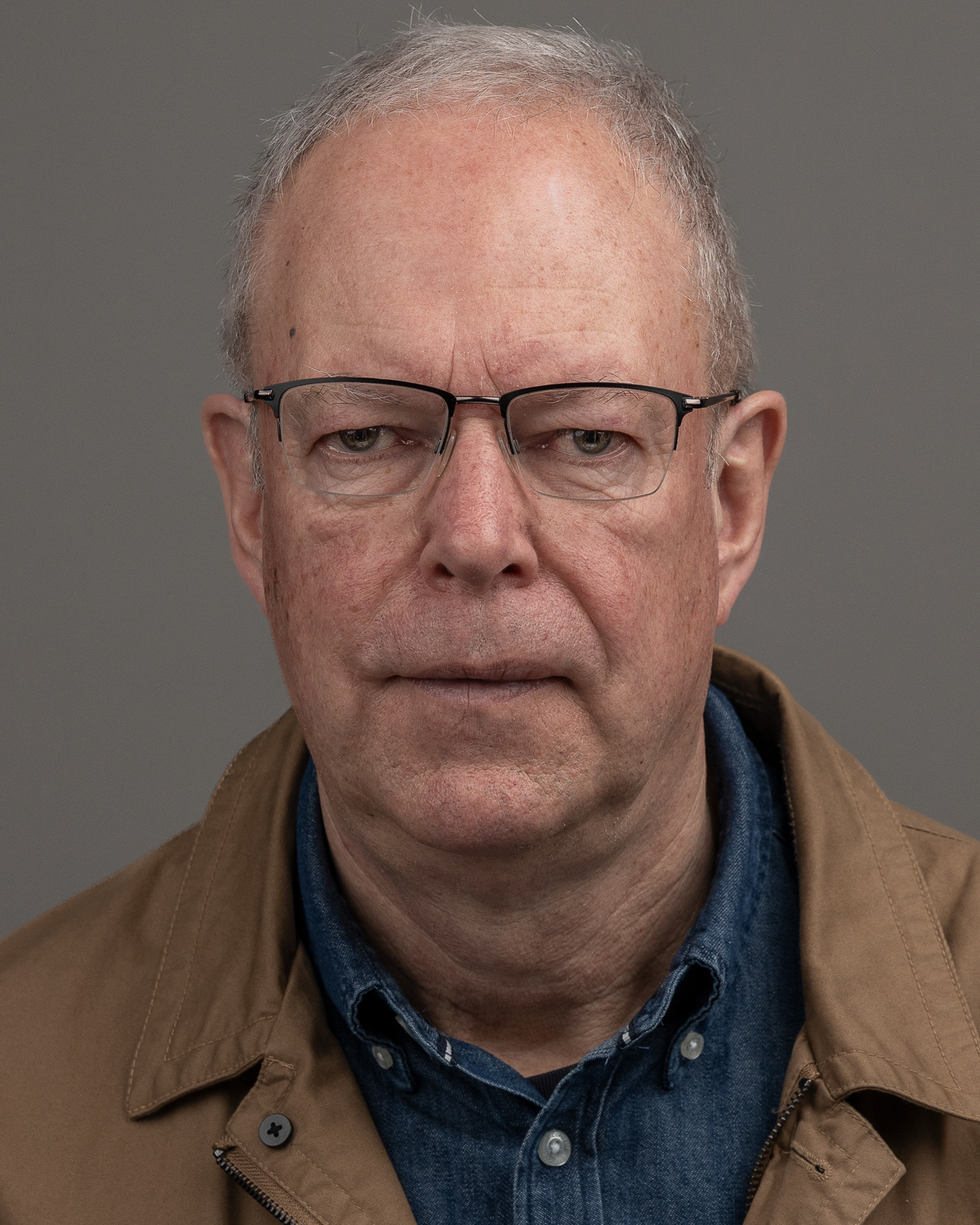 Headshot, front-facing, grey backdrop