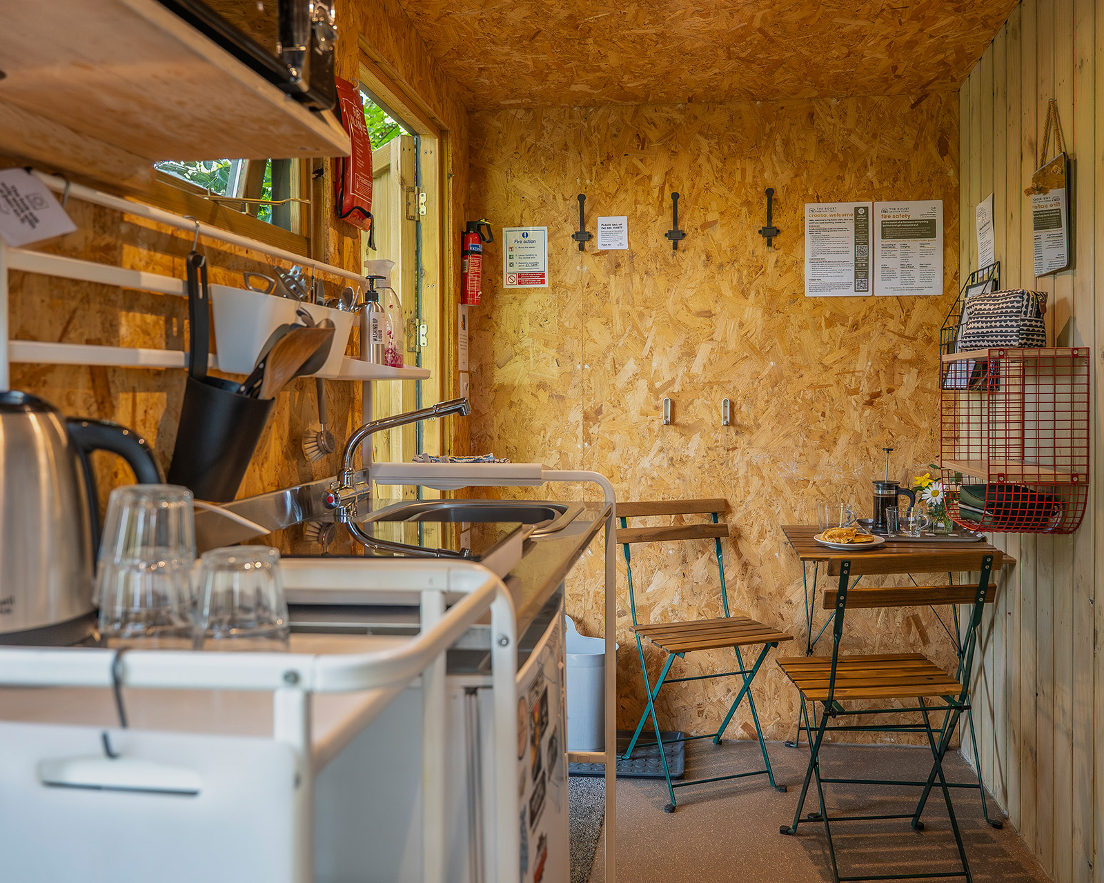 The kitchen and dining area inside Arosfa cabin at Roost Merthyr Tydfil, showing the compact, well-equipped space designed for comfortable self-catering during a South Wales glamping stay.