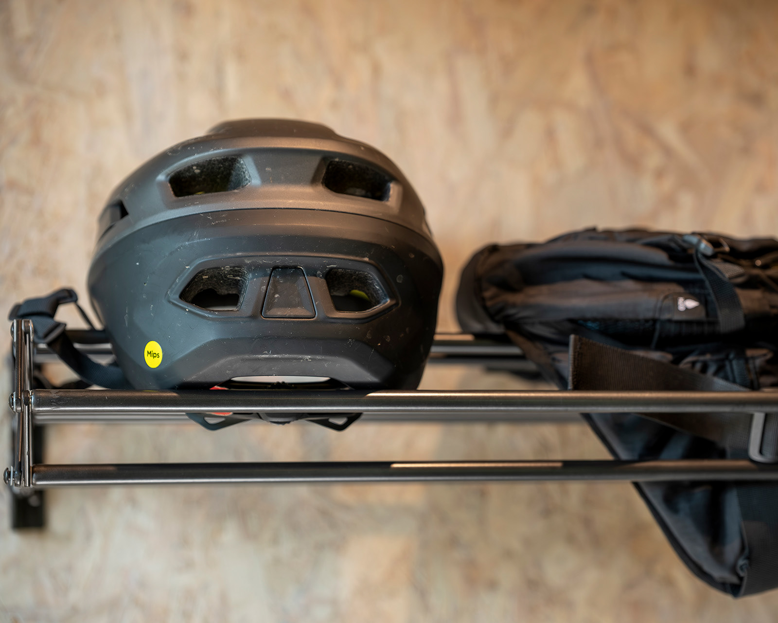 A close-up of a cycling helmet and rucksack on the storage rack at Noddfa cabin, Roost Merthyr Tydfil, highlighting the practical facilities for guests exploring South Wales by bike.