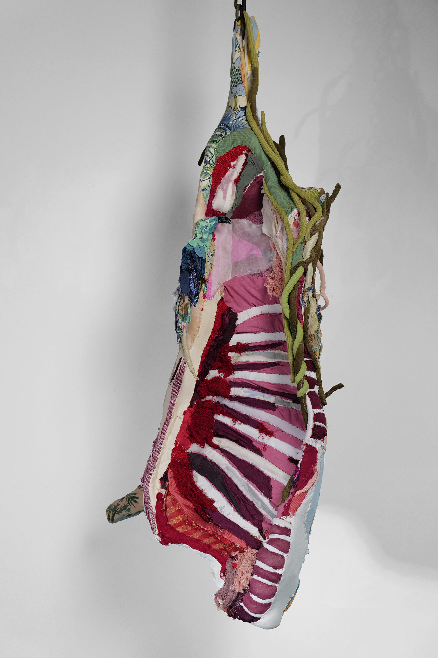 "Cow Turns into a Landscape" 2021 (Front view) | Discarded clothing, metal chains, meat hooks | 68 x 16 x 29 in.