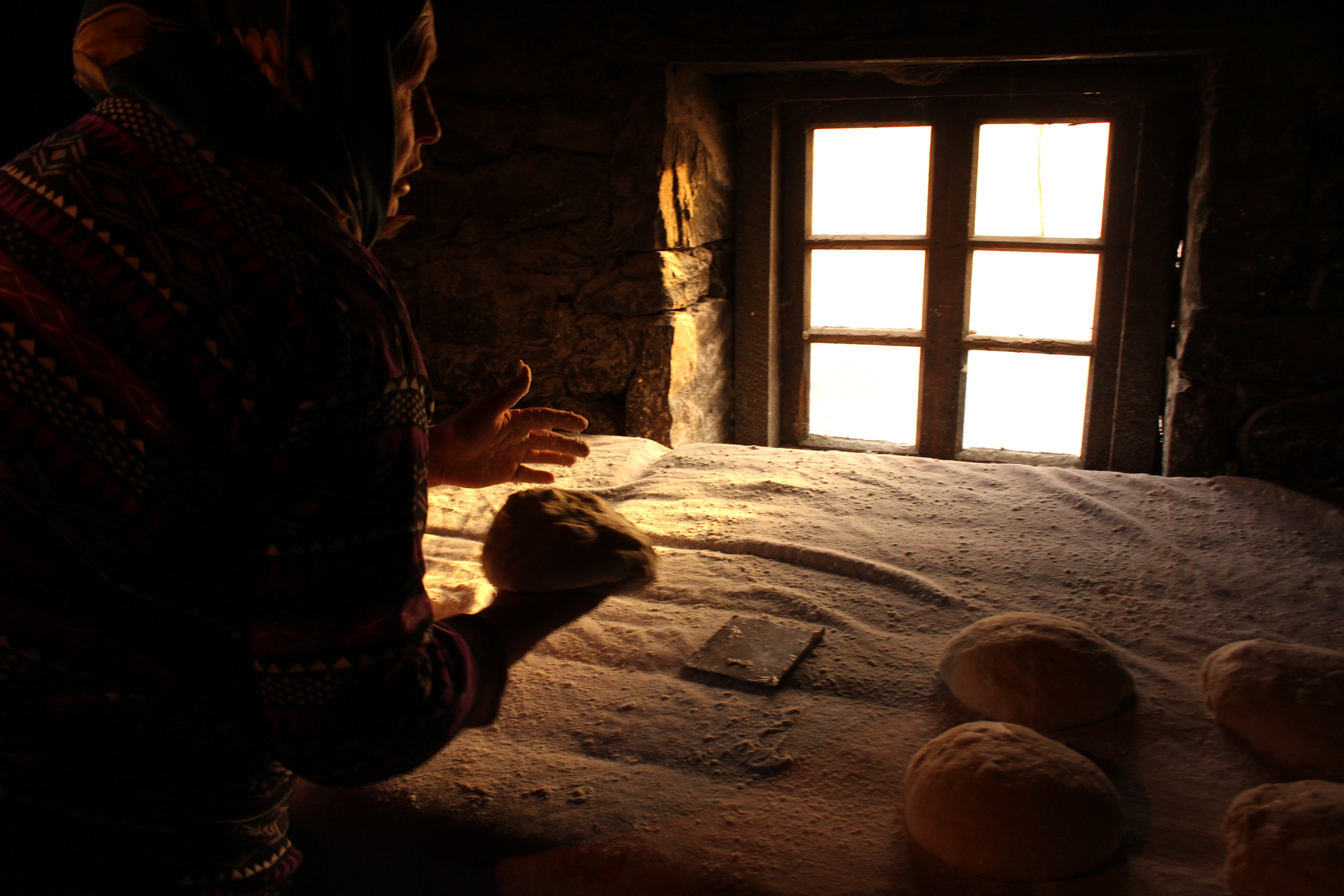 Bread dough ready for baking in one of Irganchai's five "public" bakeries - small rooms that mirror the villagers' deeply rooted sense of community. Local families set up the stone wood - fired ovens in their courtyards, and any villager who wants to bake bread can use them for free if they give the owner a loaf. By tradition, goose feathers should be used to clean the ovens and dust flour from the loaves.  
