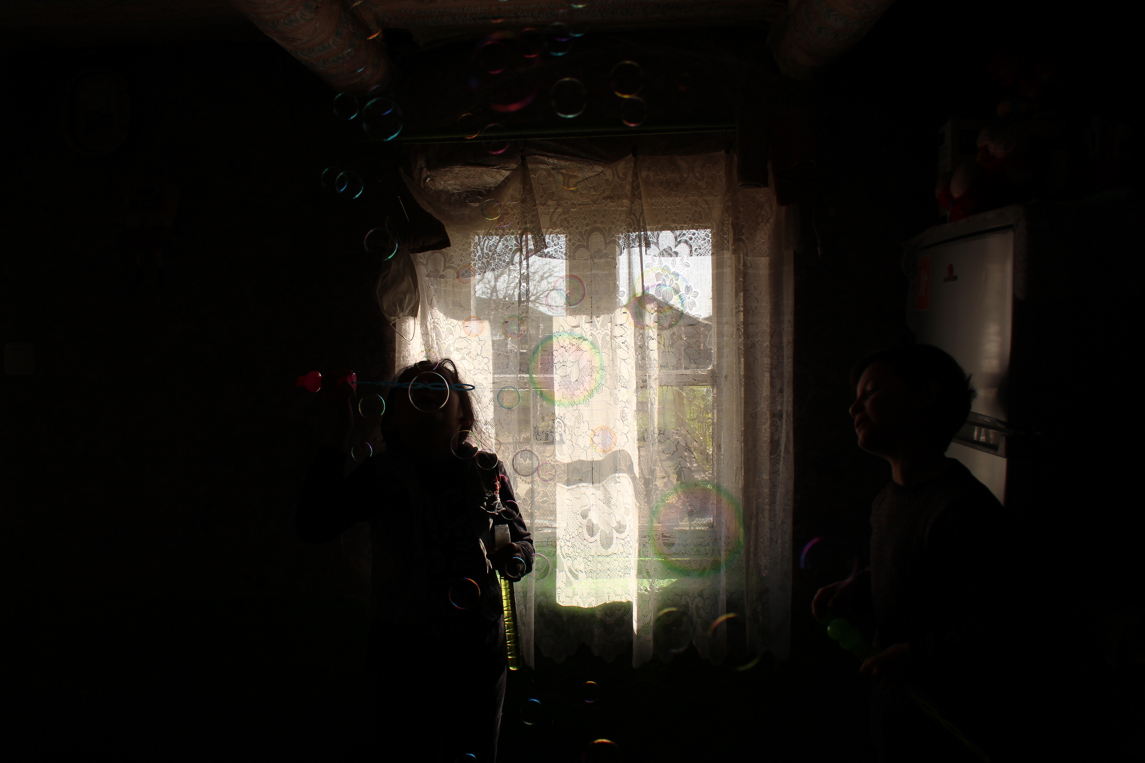 Yetar's grandchildren, Laile and Murad blowing soap bubles on a sunny spring day.