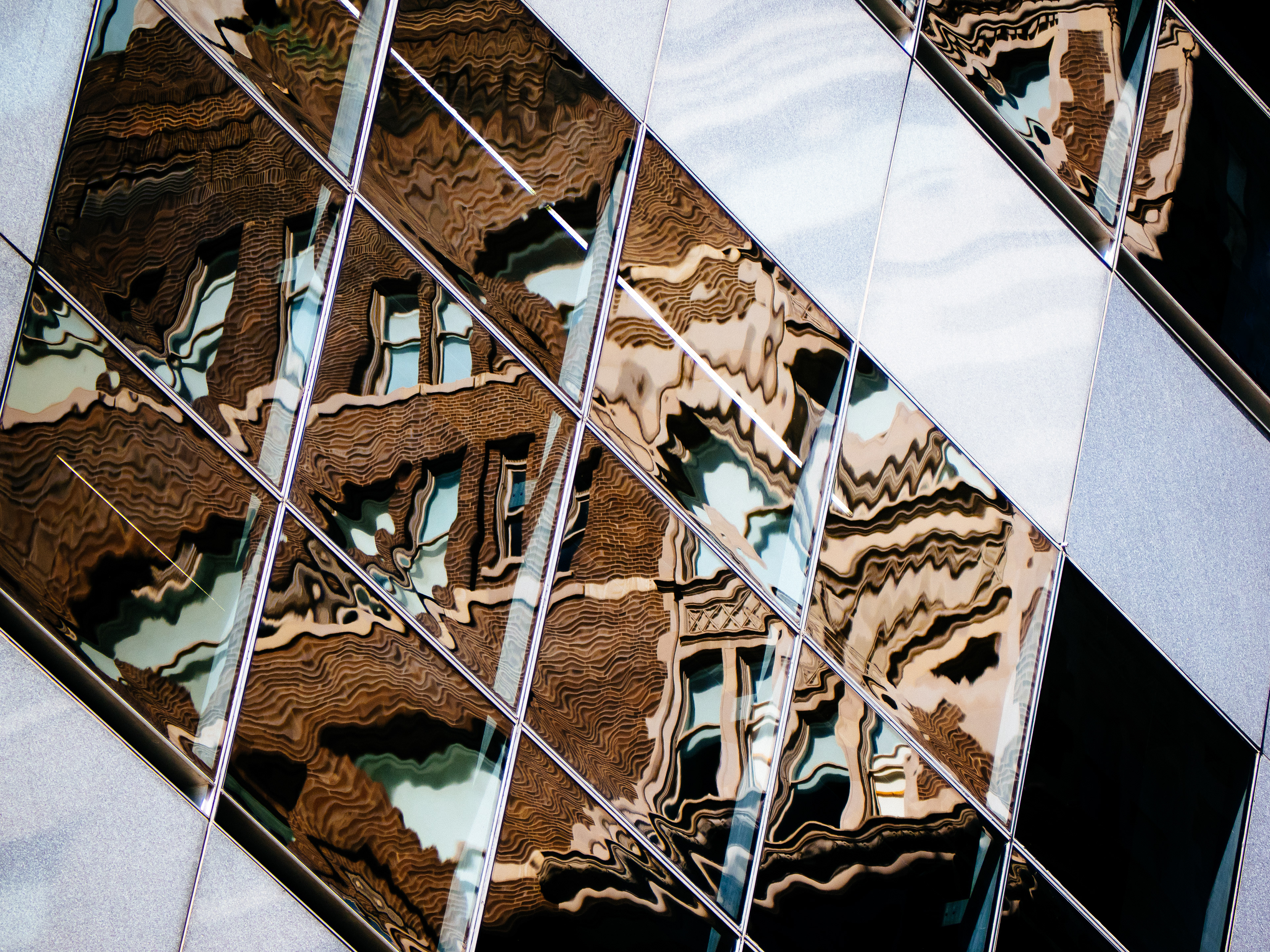 An old brick building is reflected in the windows of a new modern skyscraper in Houston, Texas, USA.