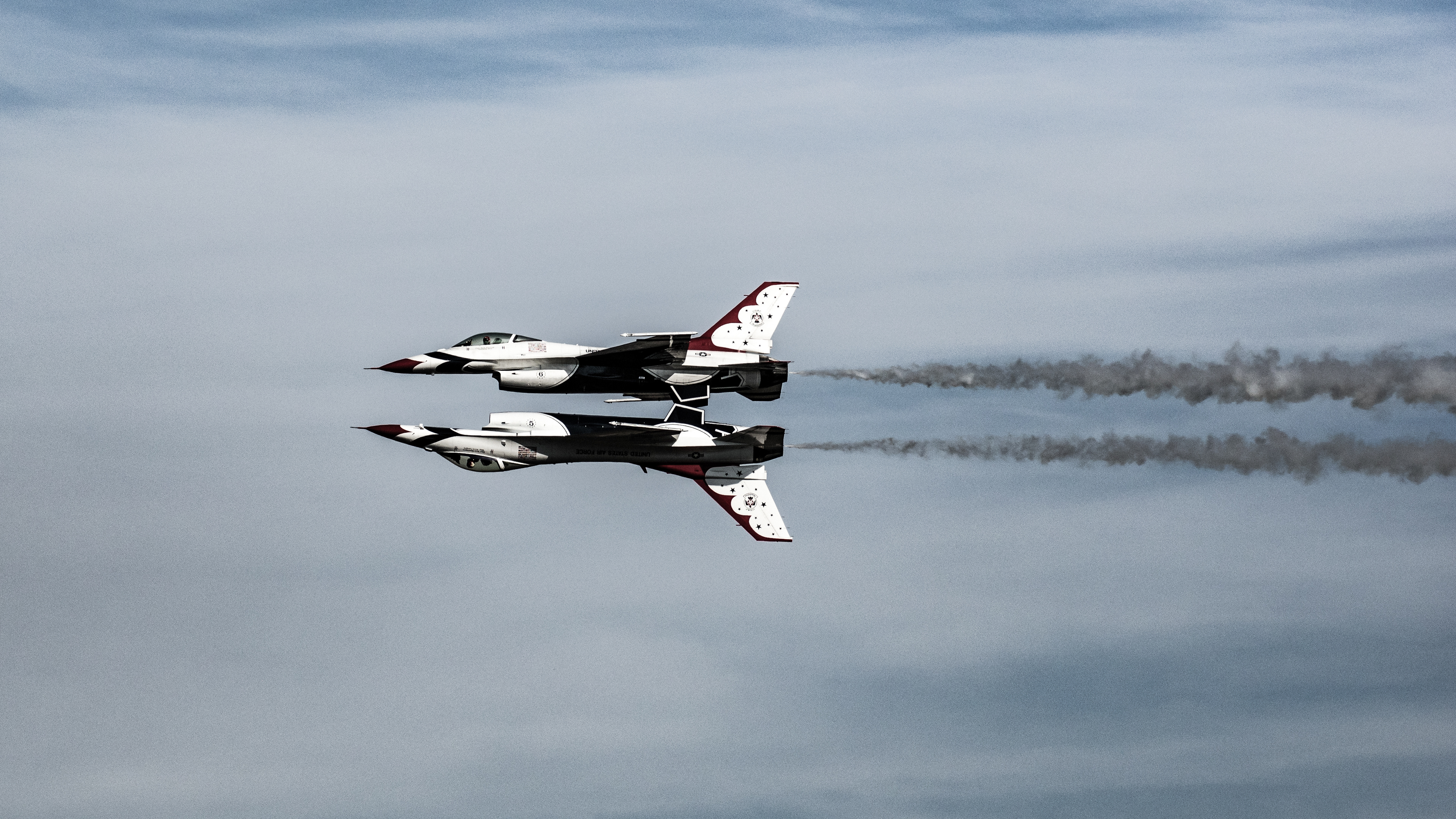 USAF Thunderbirds performing at the 2015 Wings over Houston Airshow, Houston, Texas, USA. Conducting the menuever known as the Reflection Pass are Lead Solo Pilot Maj. Jason Curtis flying inverted in Thunderbird 5 and Opposing Solo Pilot Capt. Nicholas Eberling in Thunderbird 6.