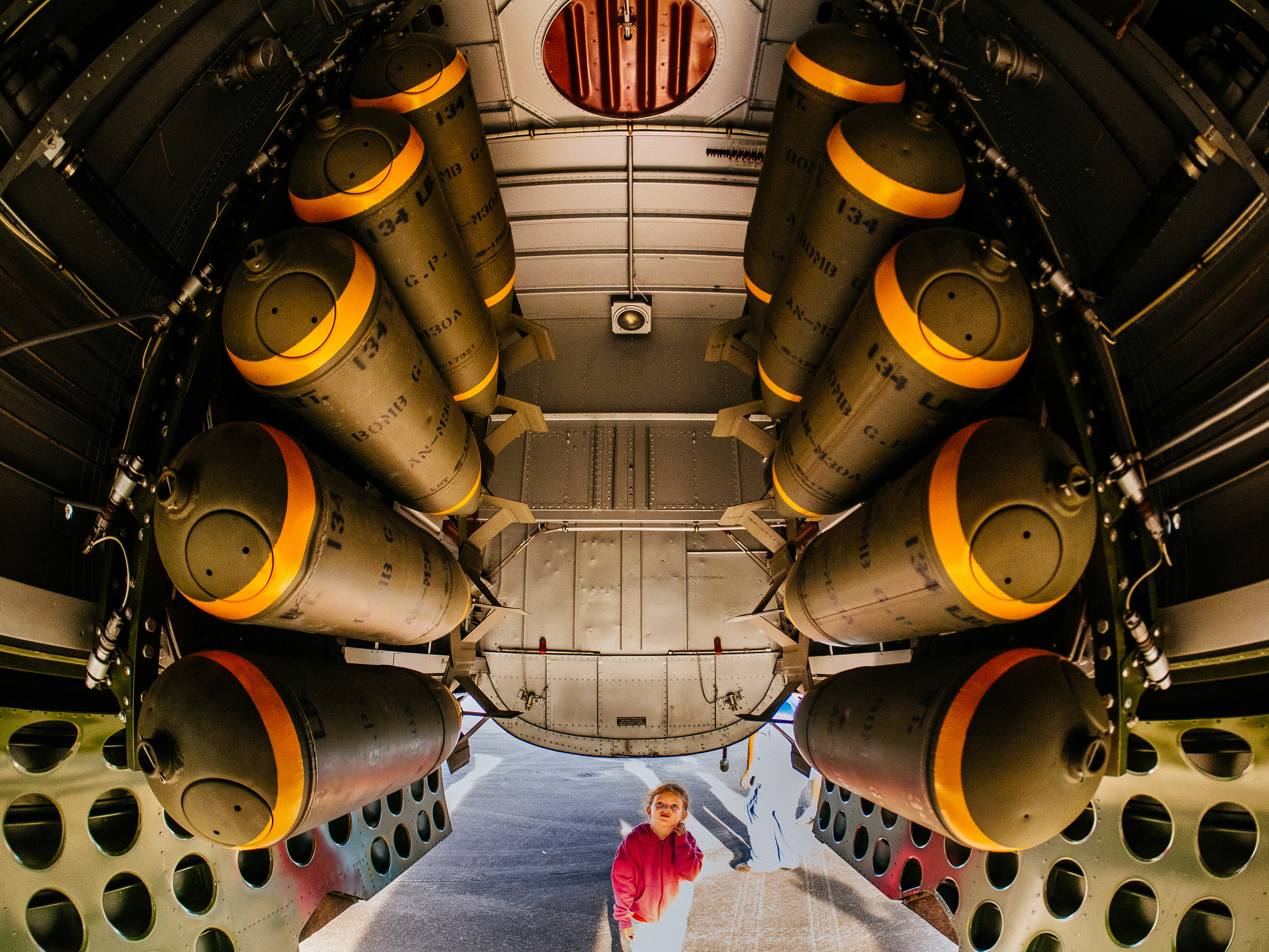 A young girl looks in amazement at the bomb compartment of Betty's Dream (a B-25J Mitchell belonging to the Texas Flying Legends) during the 2015 Wings Over Houston Airshow, Houston, Texas, USA.